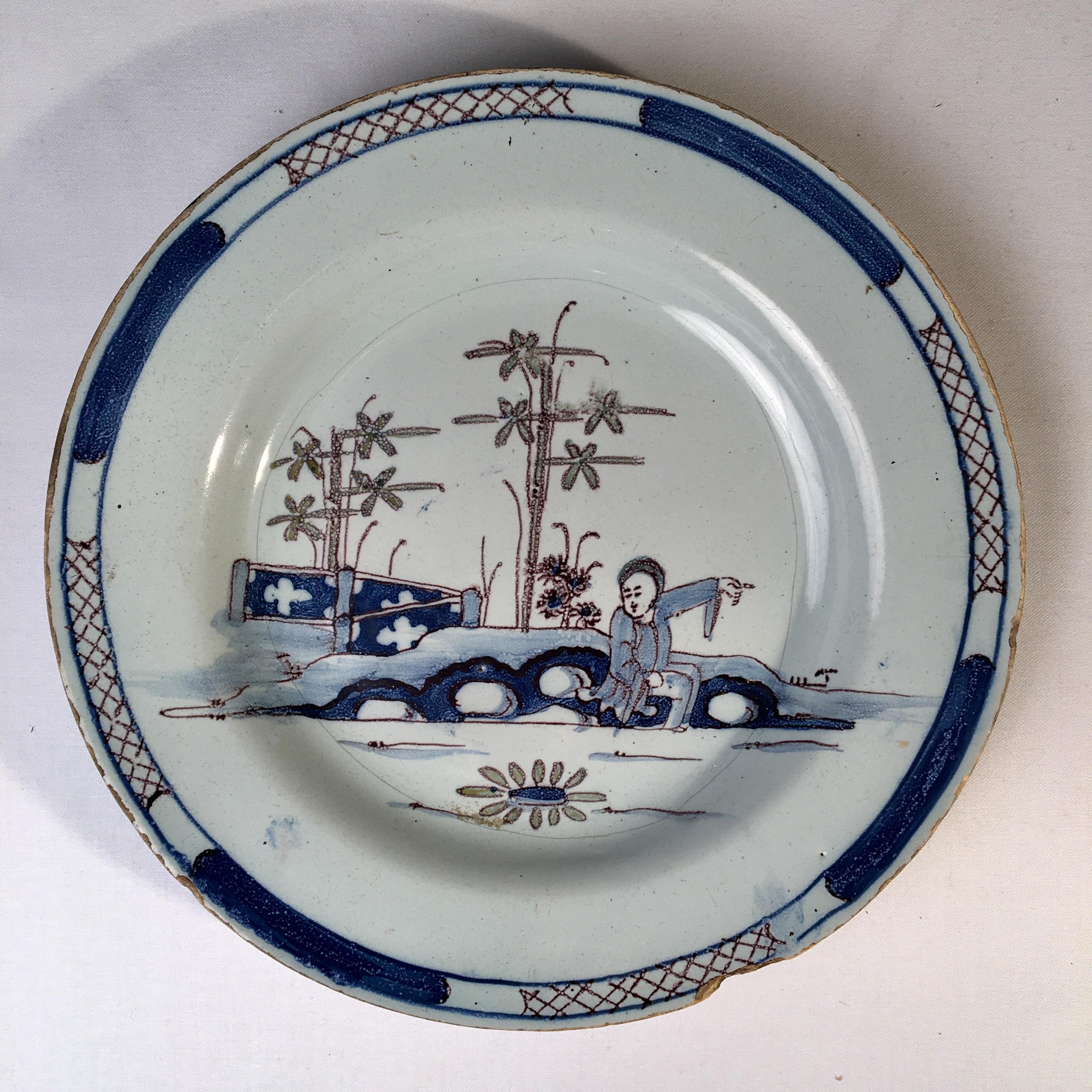 A Chinese-style delft plate, in blue and white glaze depicting a figure near a bridge, late 18th century.