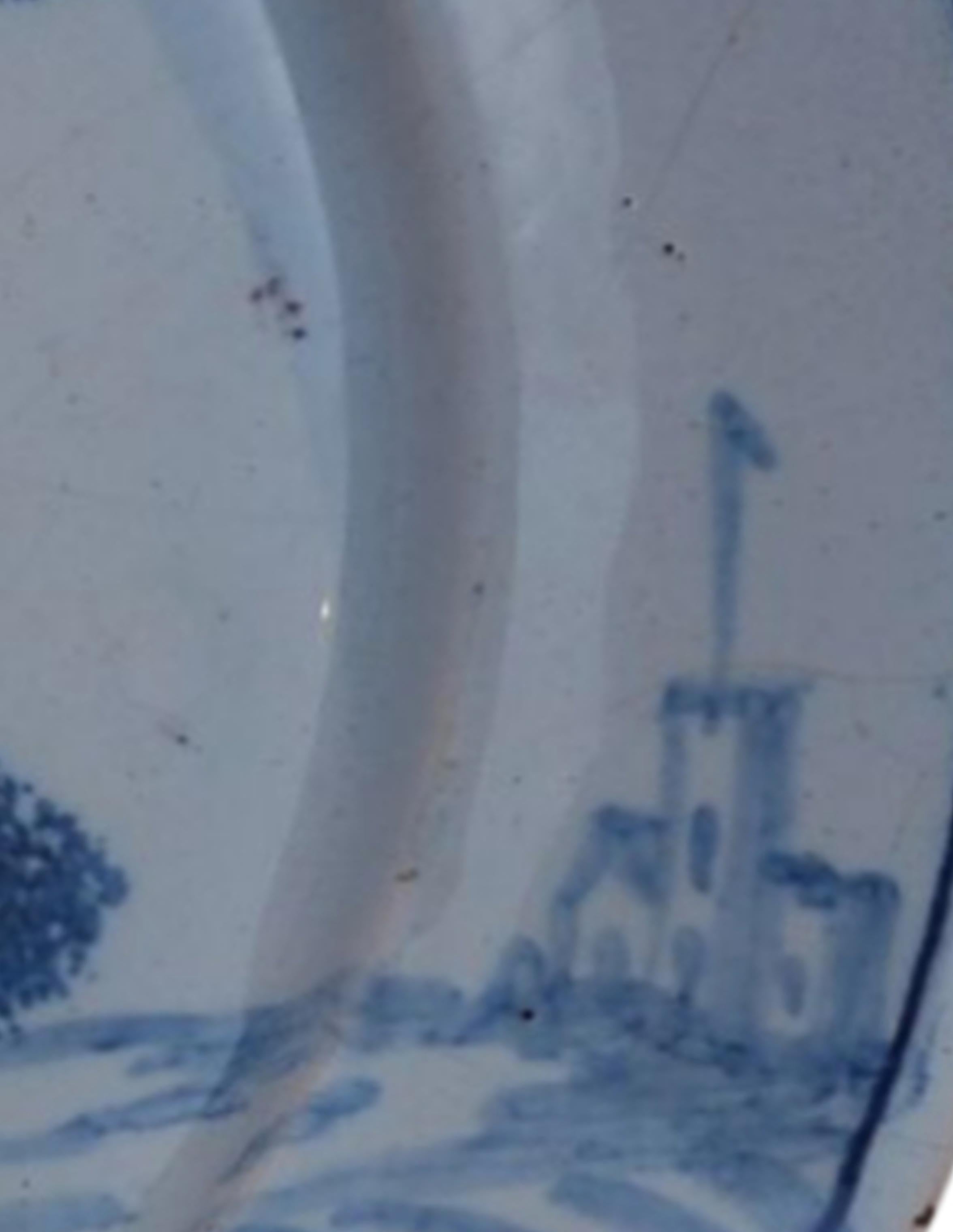 Turned Delft plate with a woman passing a monument. England C1745. For Sale