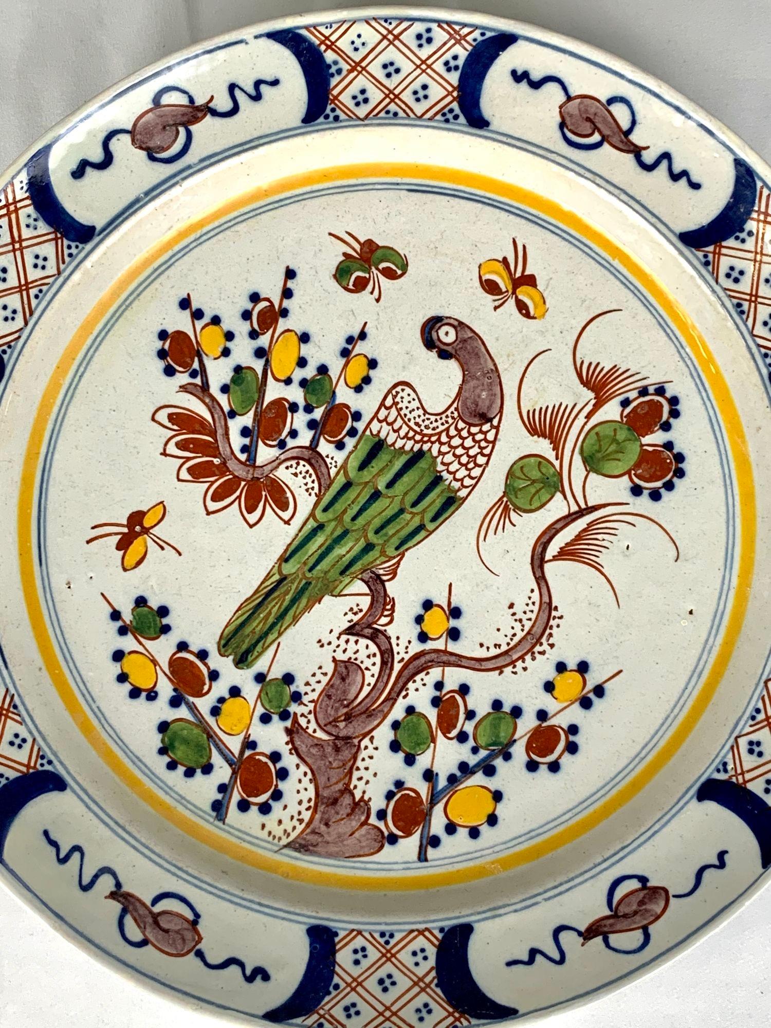 This 18th century Dutch Delft charger features a vibrant array of polychrome colors; yellow, green, blue manganese, and iron red.
The intensity of the colors is exquisite. The colors pop!
We see a beautiful songbird settled on a flowering tree