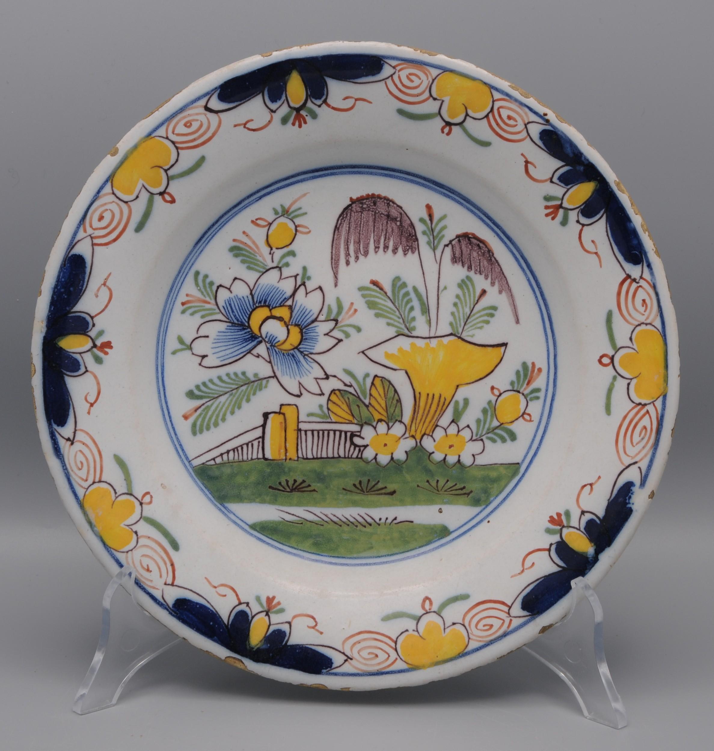  Assiette en faïence du début du 19e siècle avec une décoration florale polychrome en jaune, bleu, vert et rouge de fer. 

Bon état ; seule une légère usure habituelle du bord.