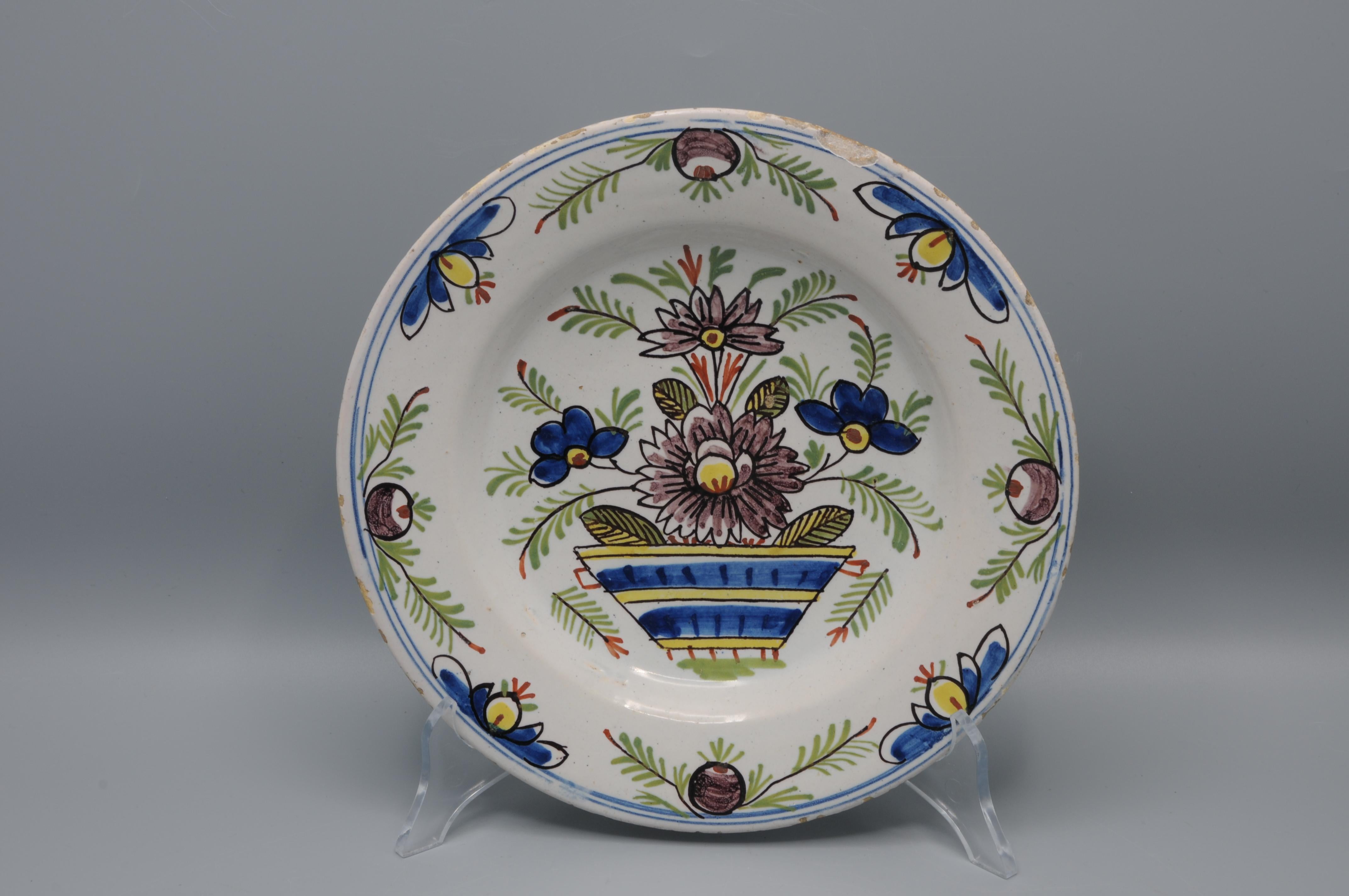  Assiette en faïence du début du 19e siècle à décor floral polychrome en jaune, bleu, vert et manganèse. 

Bon état ; seule une légère usure habituelle du bord.