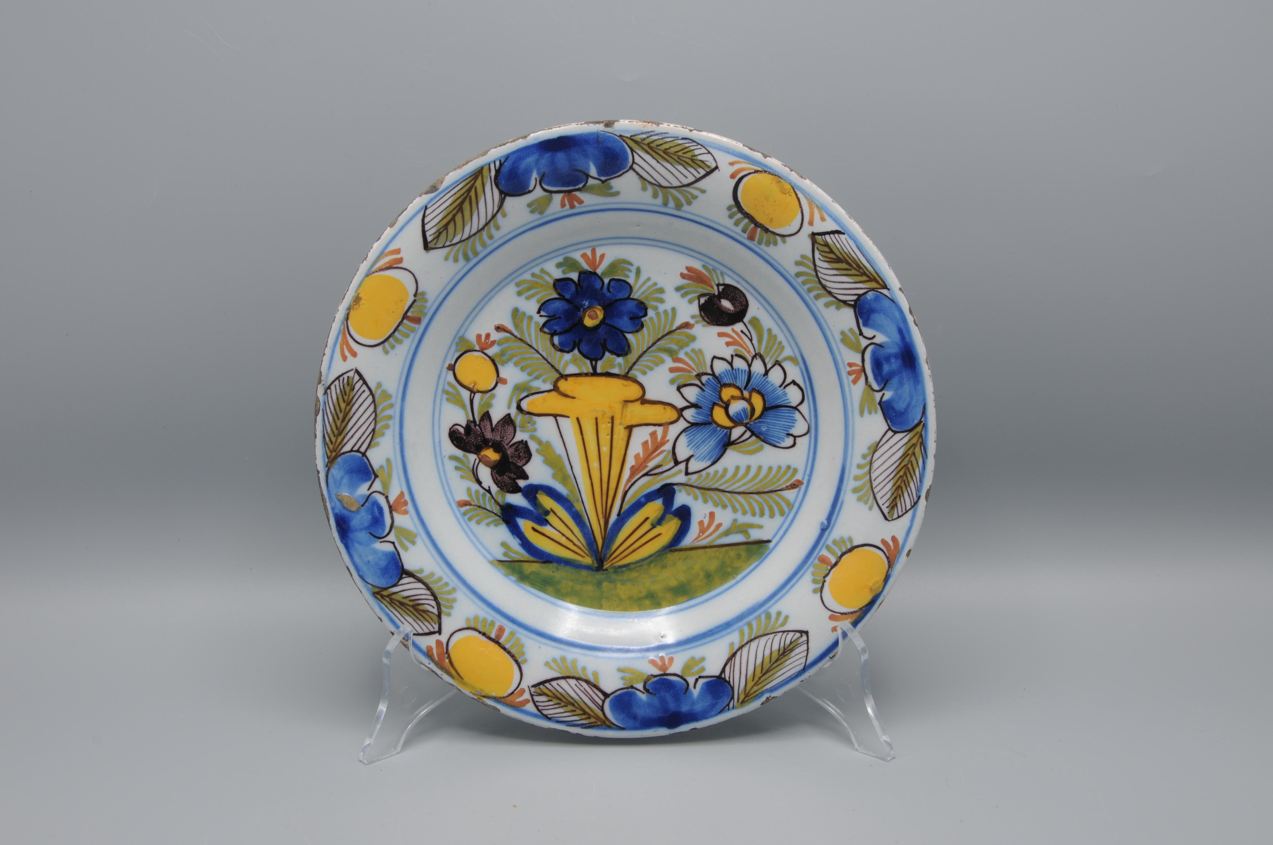  Early 19th century Delftware plate with bright polychrome floral decoration in yellow, blue, green and manganese. 

Good condition; only slight usual wear to the rim