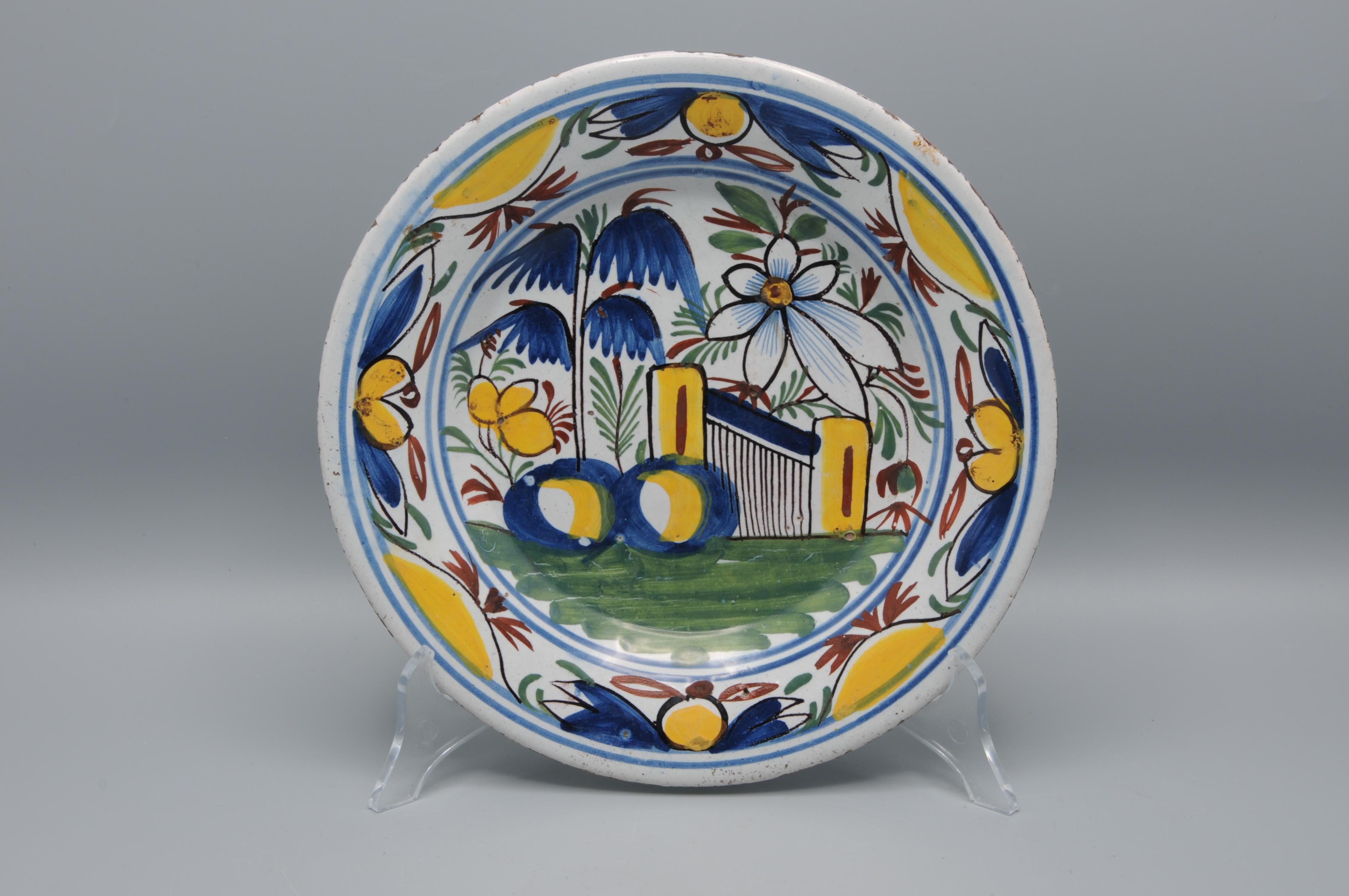 Early 19th century Delftware plate with bright polychrome floral decoration in yellow, blue, green and iron-red. 

Good condition; only slight usual wear to the rim