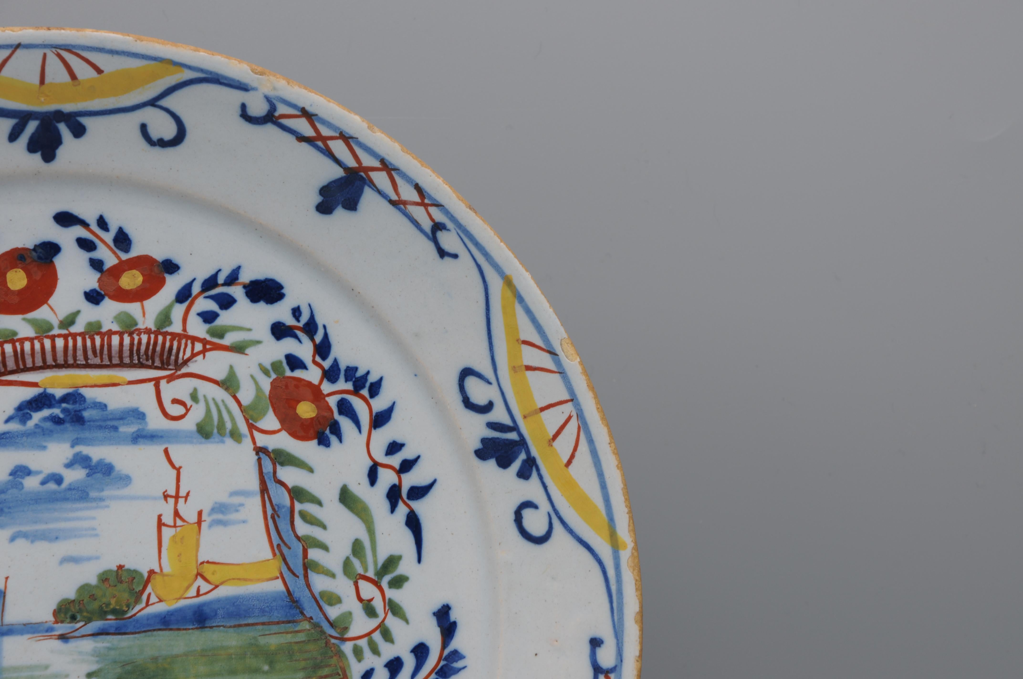 Vernissé Assiette polychrome de Delft représentant un paysage avec des navires - 18e siècle en vente