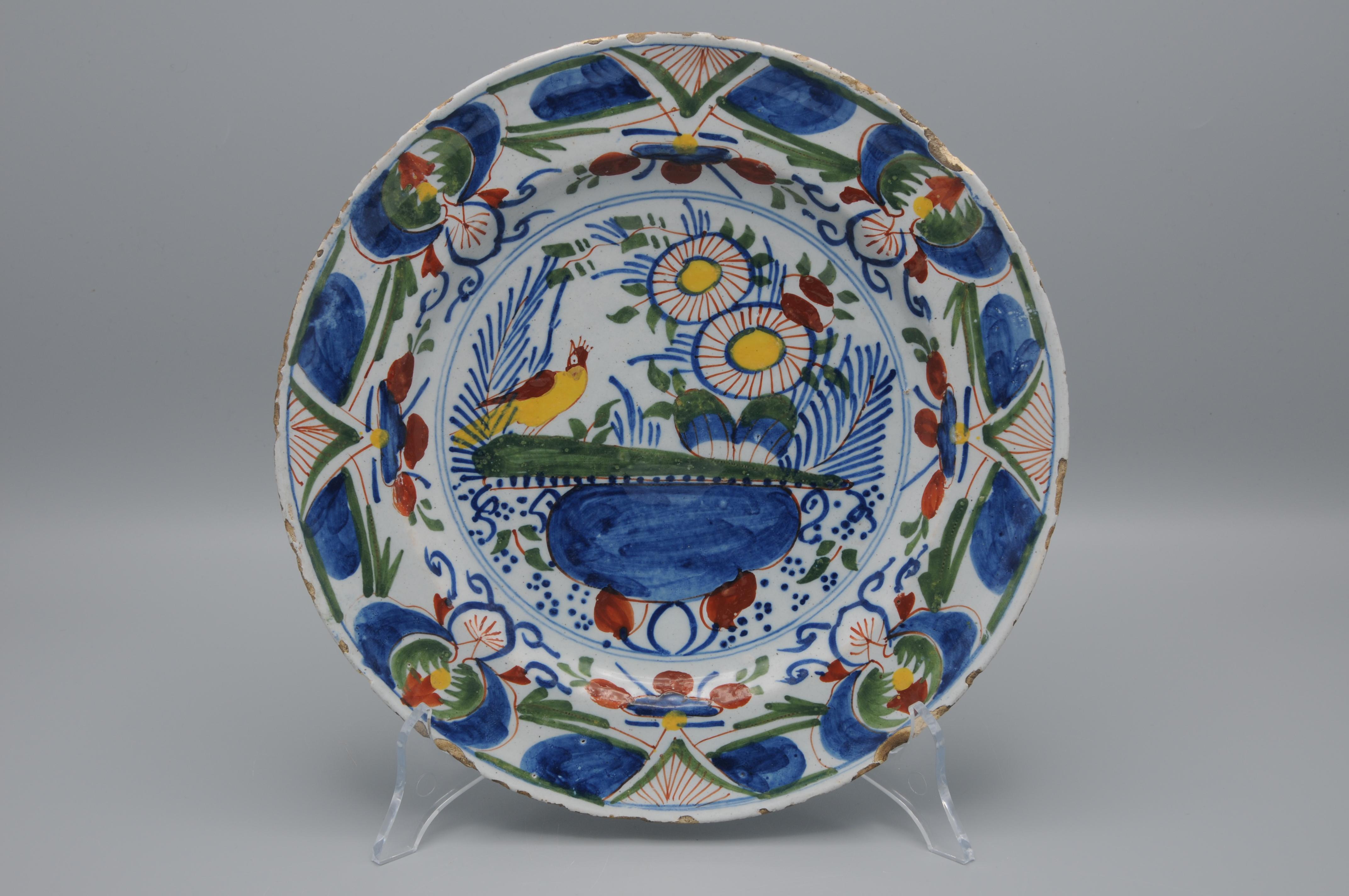 18th century Delftware plate with bright polychrome decoration of a flower vase flanked by an exotic bird

unmarked

Good condition: only slight wear to the rim, two larger chip (see picutres)