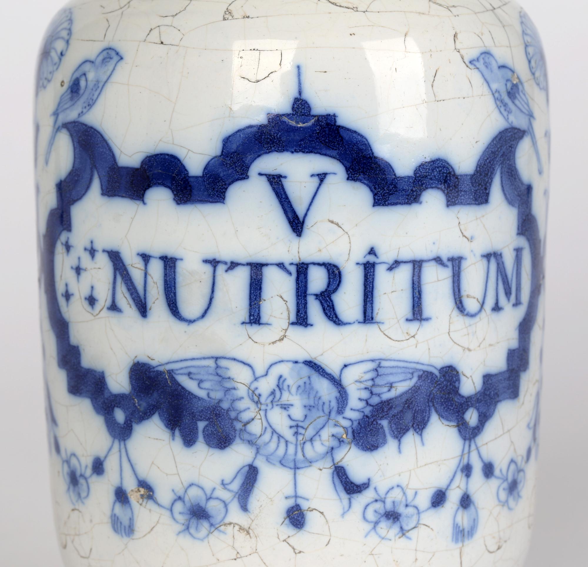 A good Delft blue and white pottery apothecary jar marked V NUTRITUM and dating from around 1720. The jar, of cylindrical form stands on a rounded pedestal foot with a pinched top rim and slightly flared top. The jar is hand decorated with a blue