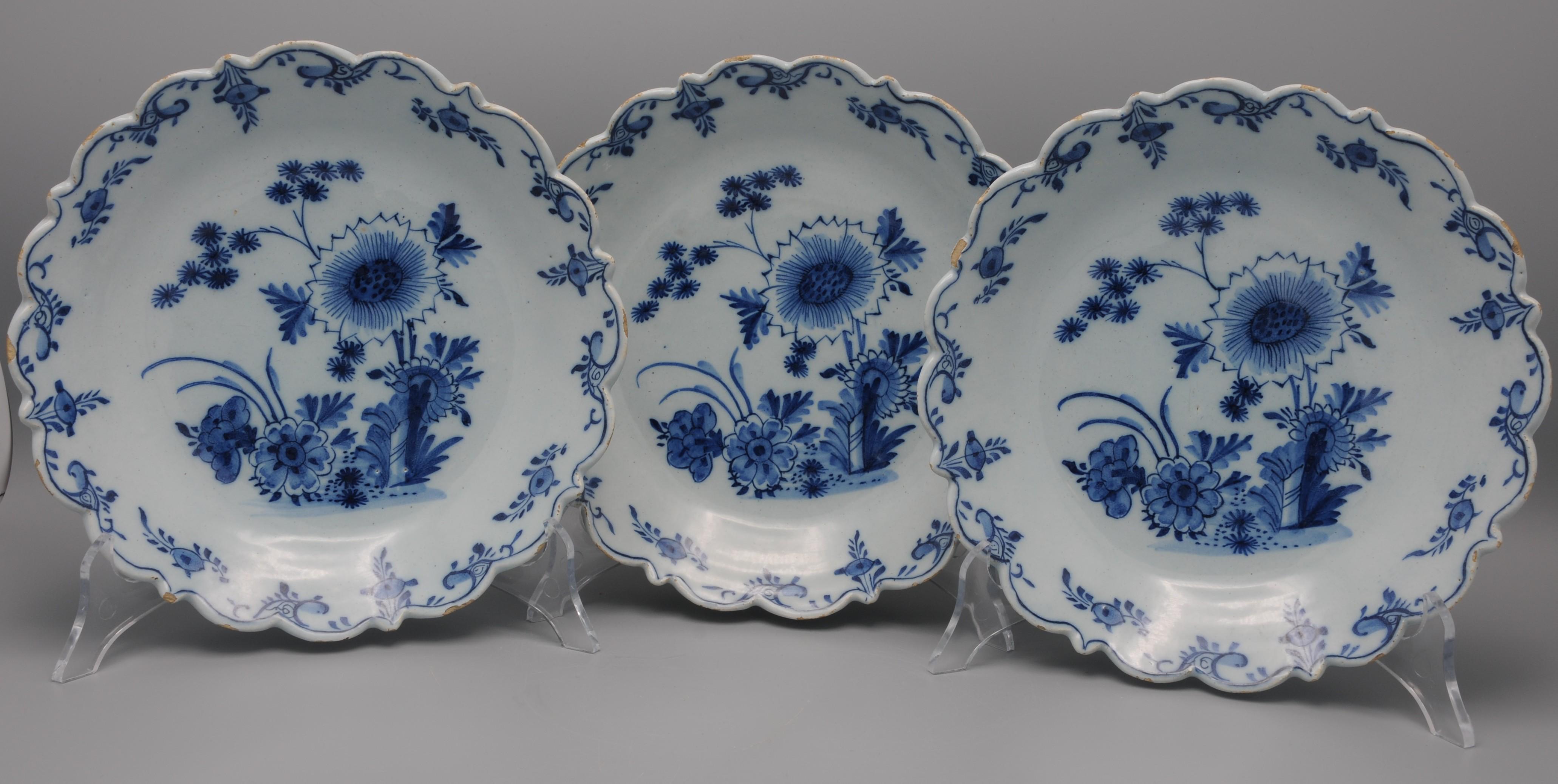 Rare et très belle série de 3 assiettes florales en bleu et blanc de Delft, décorées d'un arrangement de fleurs et de fleurs finement peint. Le rebord cannelé et échancré est décoré de bourgeons de fleurs stylisés. 
seconde moitié du XVIIIe