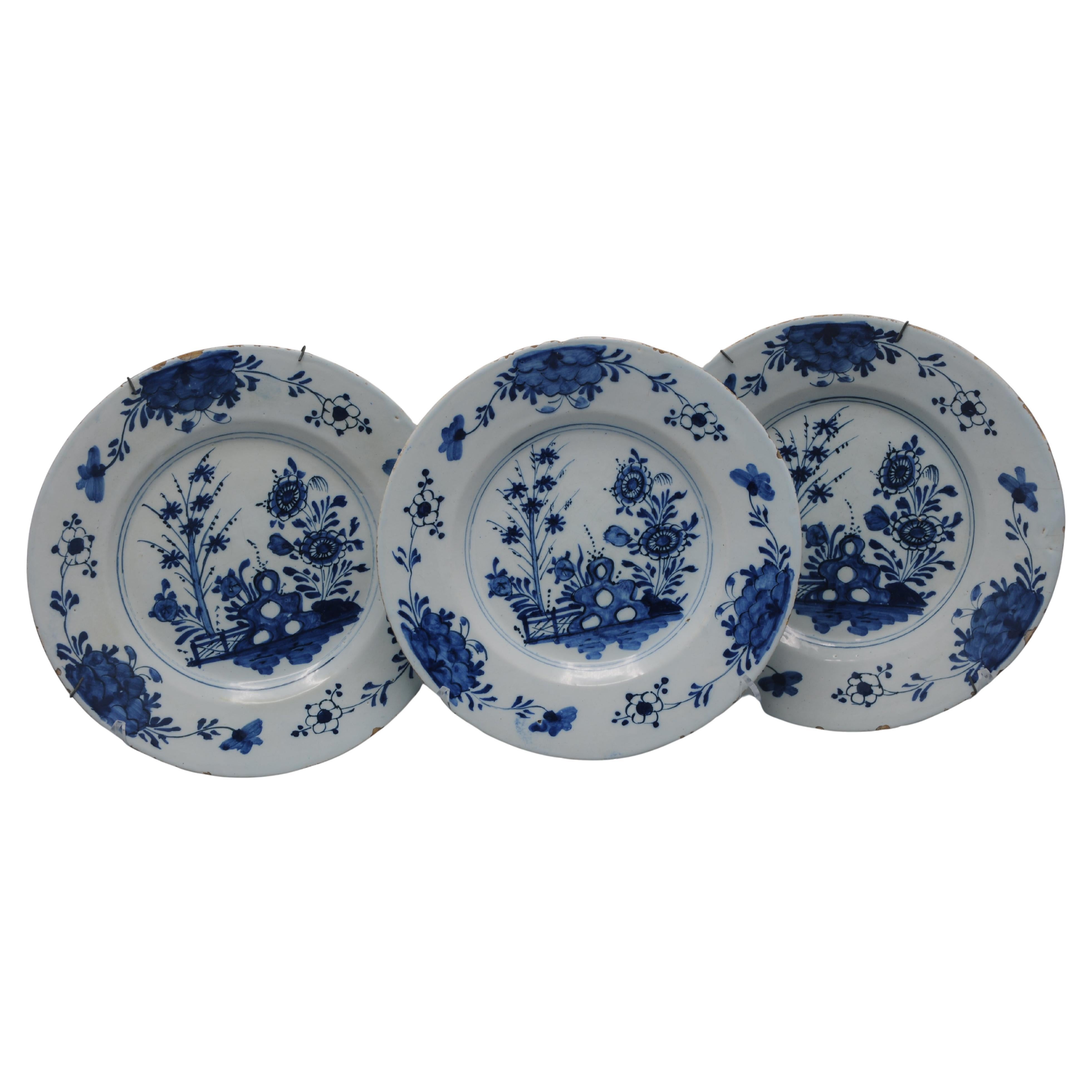 Ensemble de trois assiettes en faïence de Delft, milieu du 18e siècle. Chaque assiette est peinte à la main en bleu cobalt sur un fond blanc émaillé à l'étain, reflétant la forte influence de la porcelaine d'exportation chinoise de la période