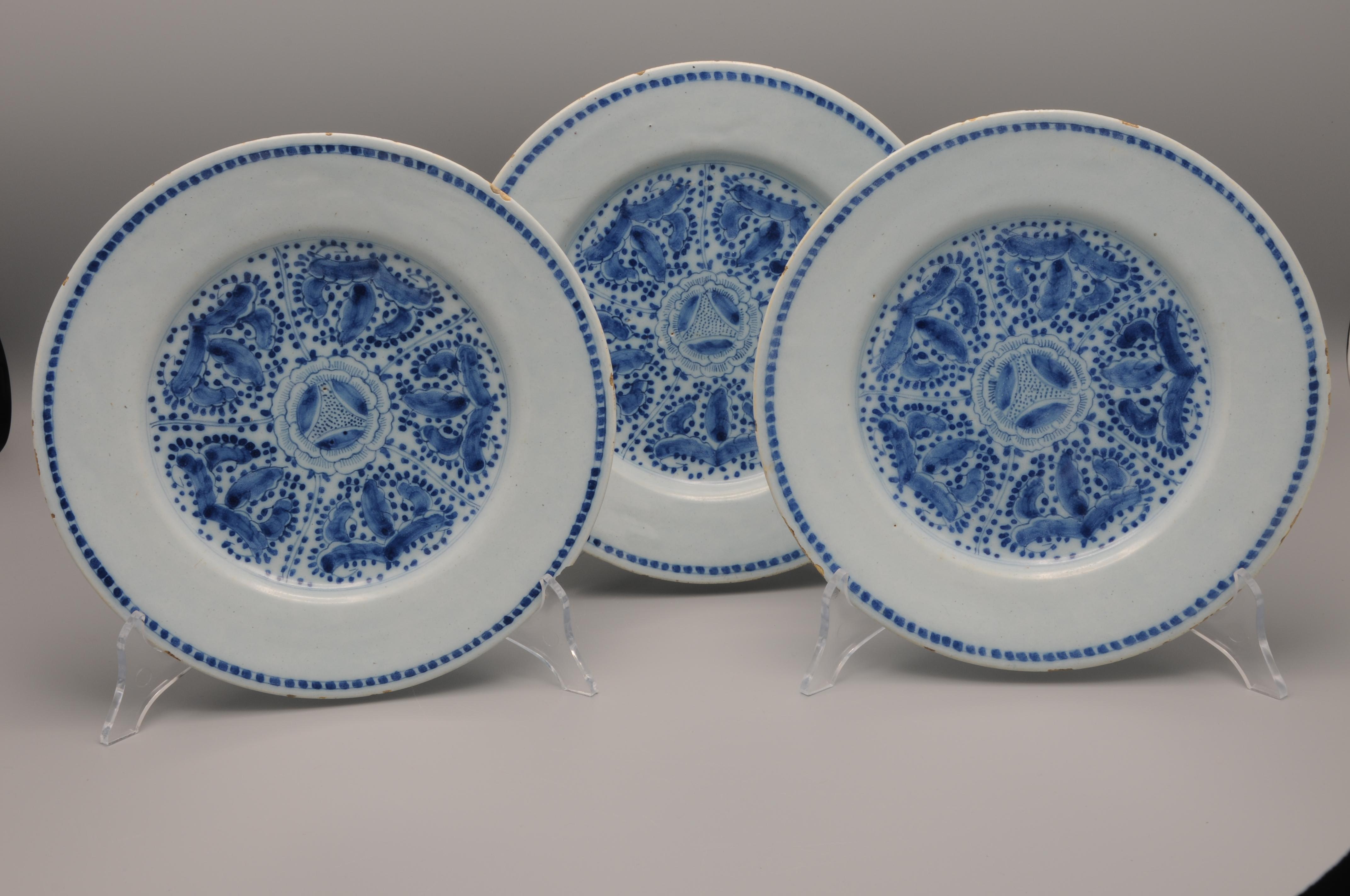Set of three Blue Dutch Delftware plates with a rare chinoiserie decoration of a central geometrical decoration of flowers.
Unmarked

In good condition: only the usual wear to the rim. 