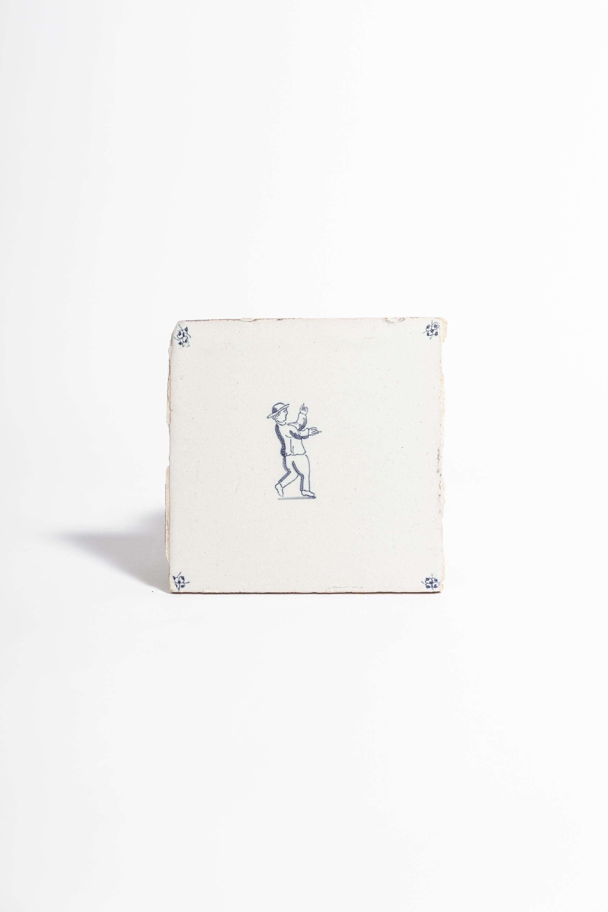 19th century delft tile.

Antique delft tile painted with central figure waving his hands and decoration in each corner. 

Dimensions: 13.5 cm x 13.5 cm.