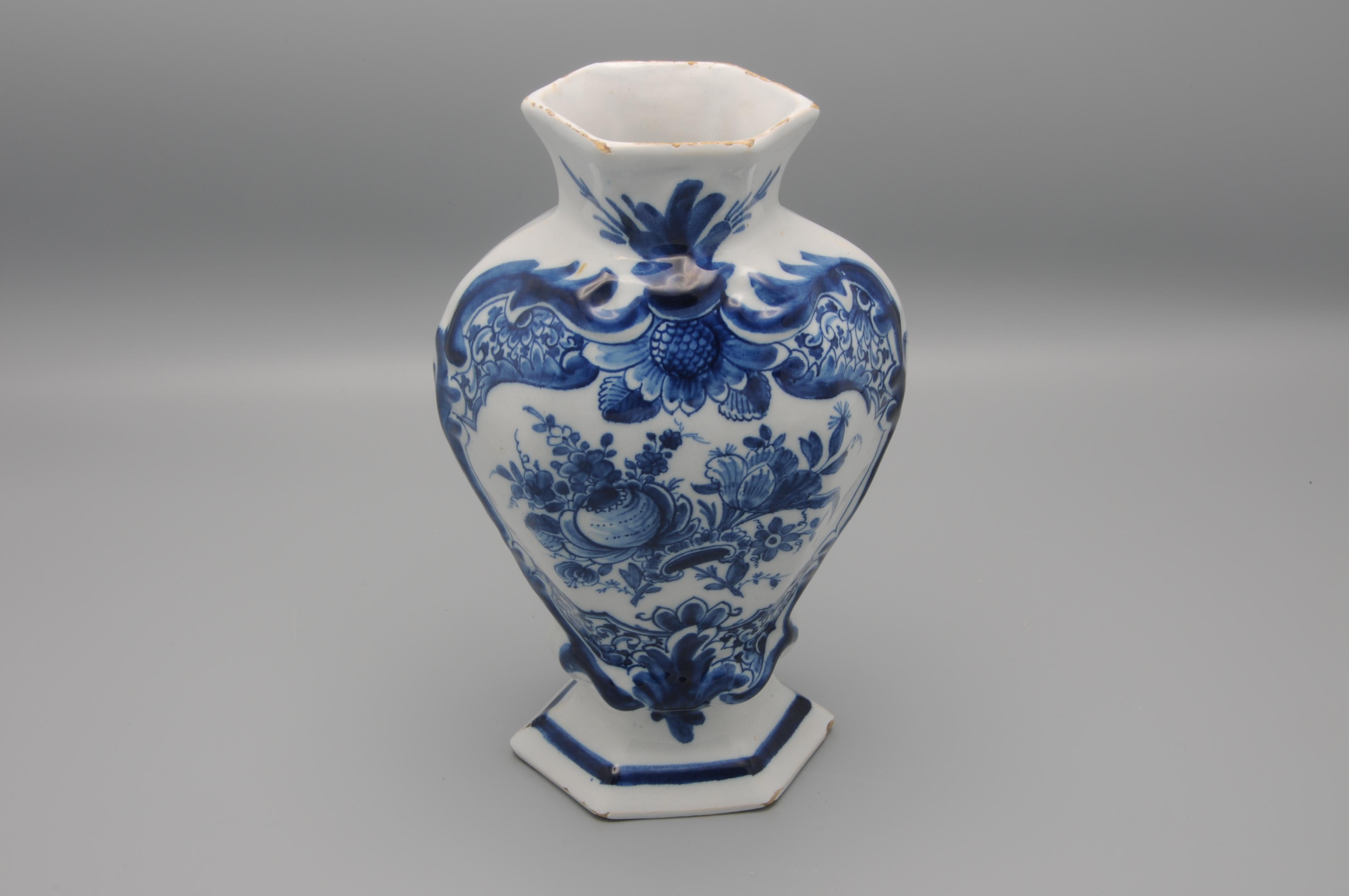 Second half 18th century Blue Delftware vase with central decoration of a flower bouquet within in a slightly raised cartouche. 

Very good condition; only light wear to the rims and some minor chipping
Marked on underside with figurative 'claw' for