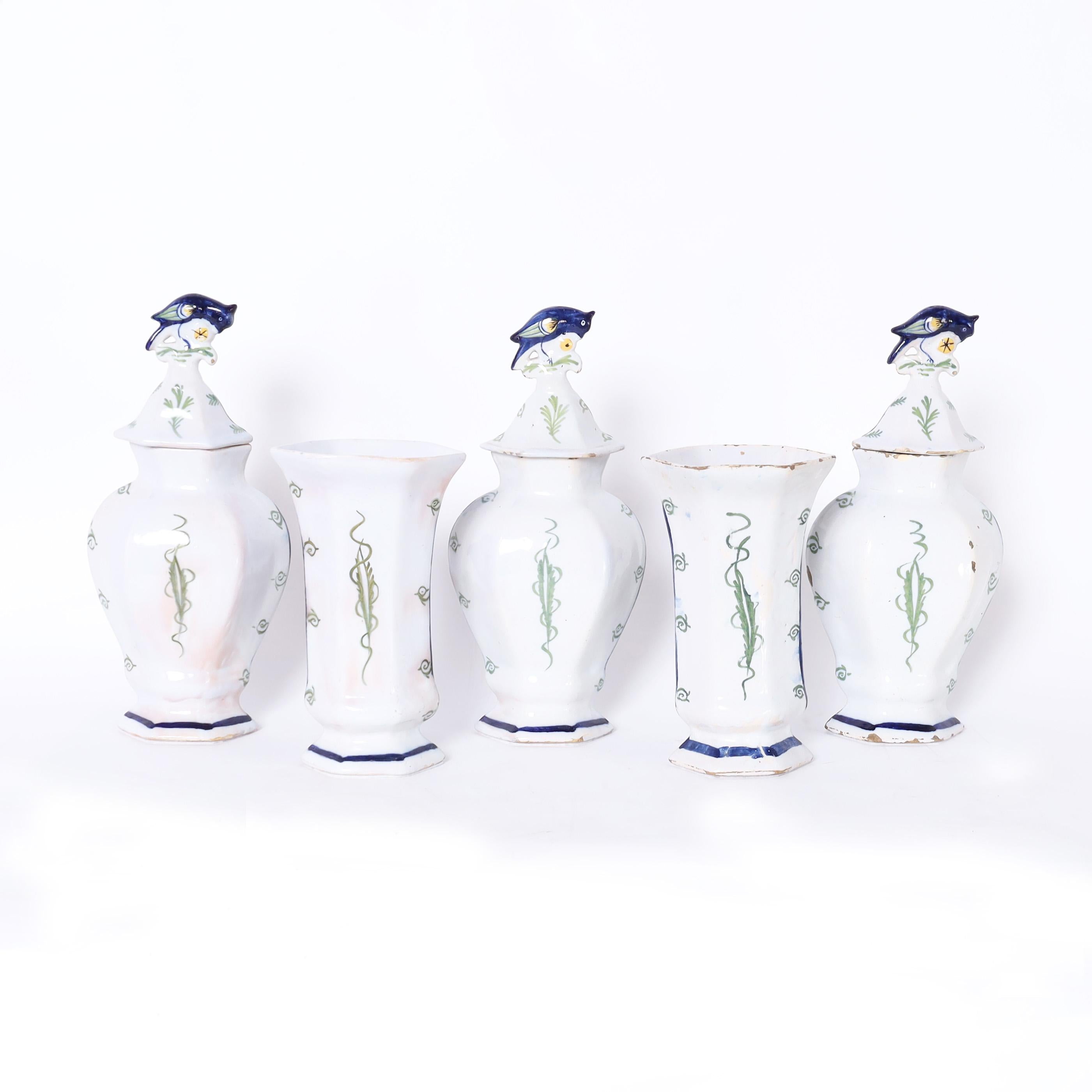 Rare and remarkable group of five English 18th century Delftware pieces, three lidded urns, and two vases crafted in terra cotta and polychrome decorated with floral motifs and glazed. Signed with the makers marks on the bottoms.

Urns- H: 13 W: 6