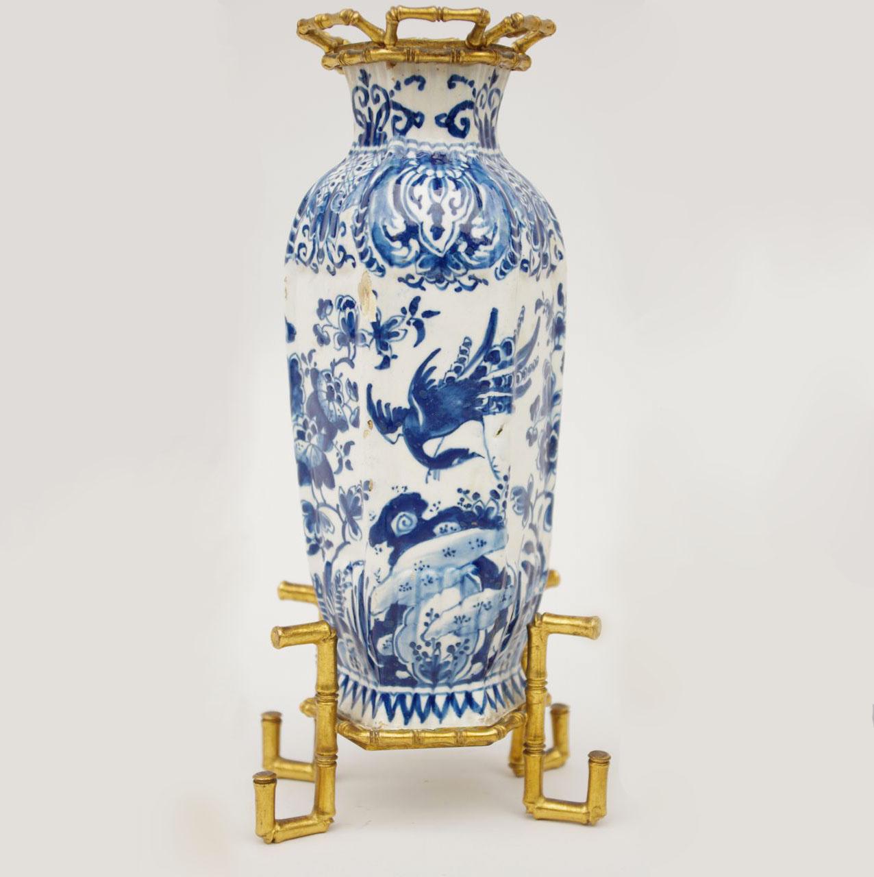Small baluster shape vase with canted corners. Blue and white decoration, typical of the Delftware production and inspired by the blue and white Chinese porcelains. The body is decorated with pots and vases filled with flowers, flowery branches and