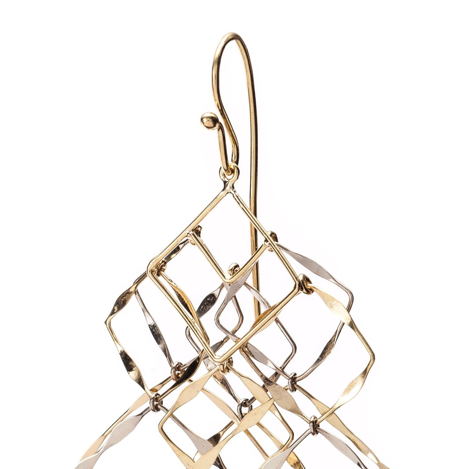 These hook earrings are hand crafted in 18K yellow and white gold. The hammered gold wire reflects light framing your features with a delicate sparkle. The earring come with tiny transparent silicone stoppers for extra security. We strongly suggest