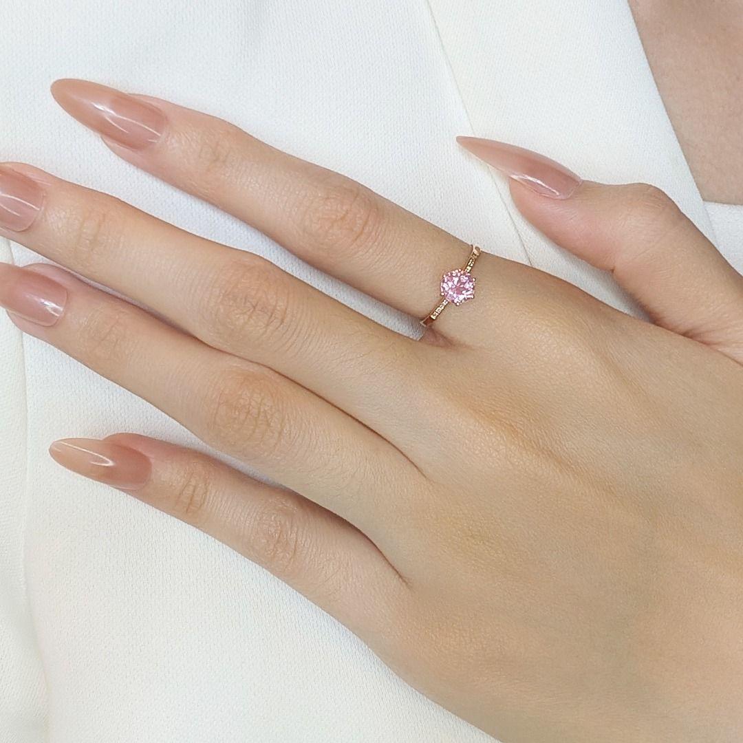 Cette exquise bague pavée, réalisée en luxueux or jaune 18 carats, témoigne d'une élégance et d'un charme raffinés. Le centre de la pièce présente une étonnante tourmaline rose ronde de 0,7ct taillée en brillant, rayonnant d'une allure douce et