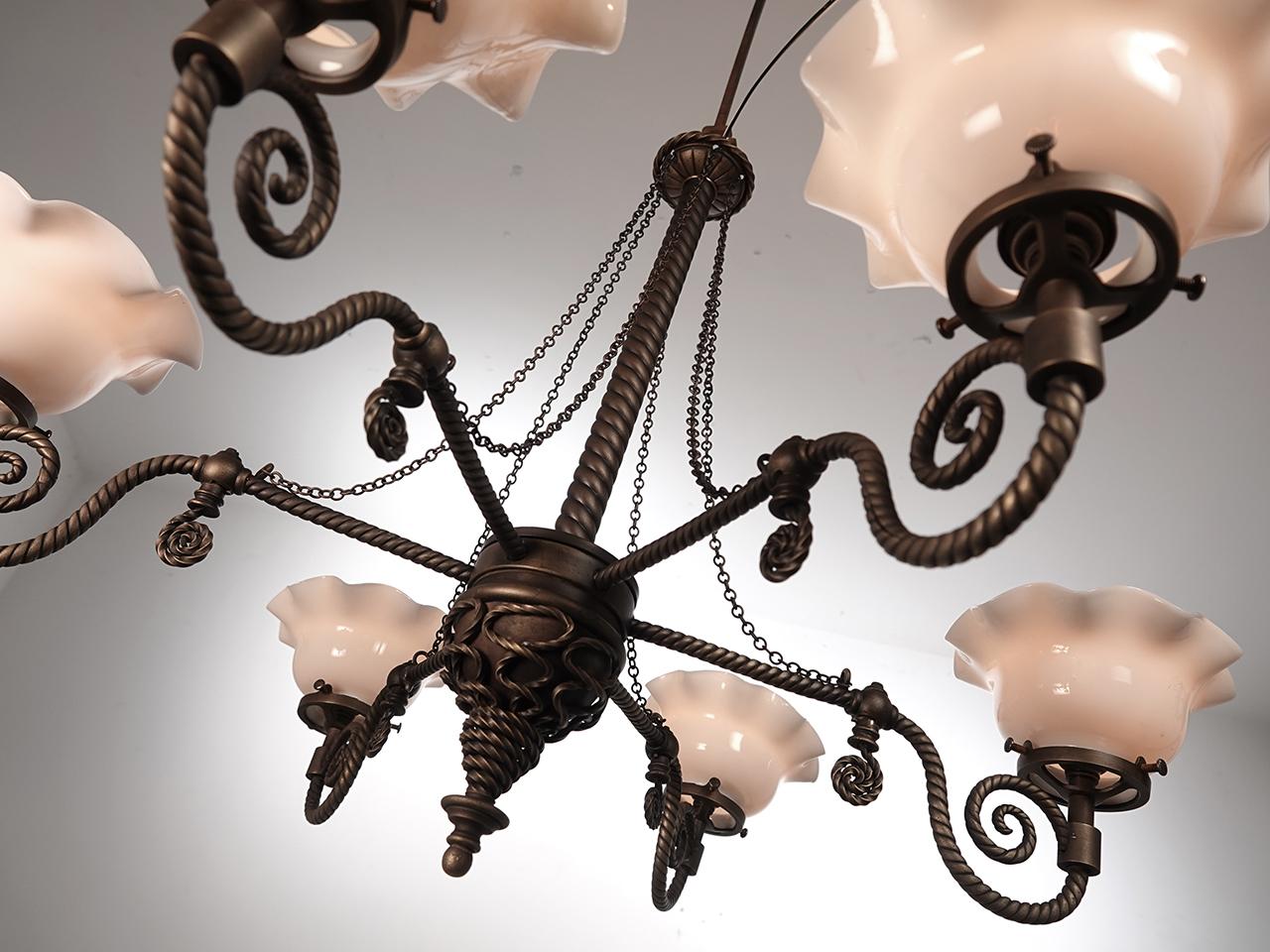 The light twisted pipe and additional twisted applied detail give this lamp its unique feel. The spiral finial ends give the lamp a Dr. Suess quality. Each arm has been wired to take an E12 candelabra bulb lighting a milk glass petticoat shade.