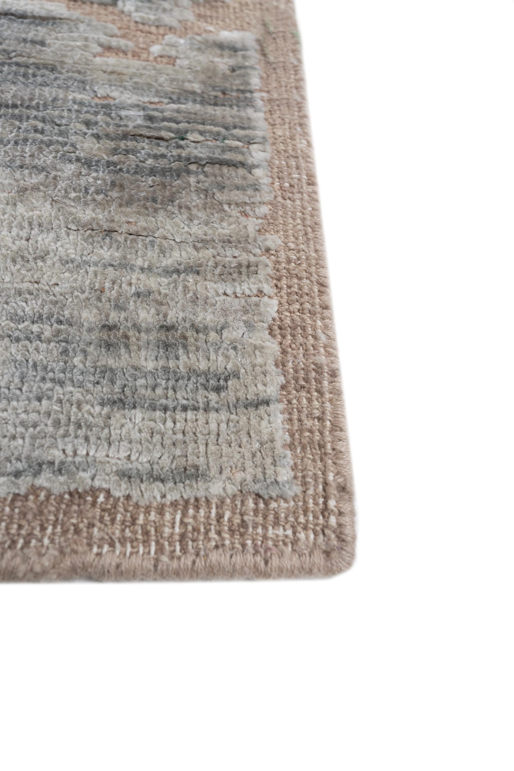 Ready to transform your space? Explore the enchanting allure of this hand-knotted modern rug. With its tone-on-tone palette, this masterpiece instantly uplifts the mood of any room, adding warmth and comfort to your floors. Meticulously handcrafted,