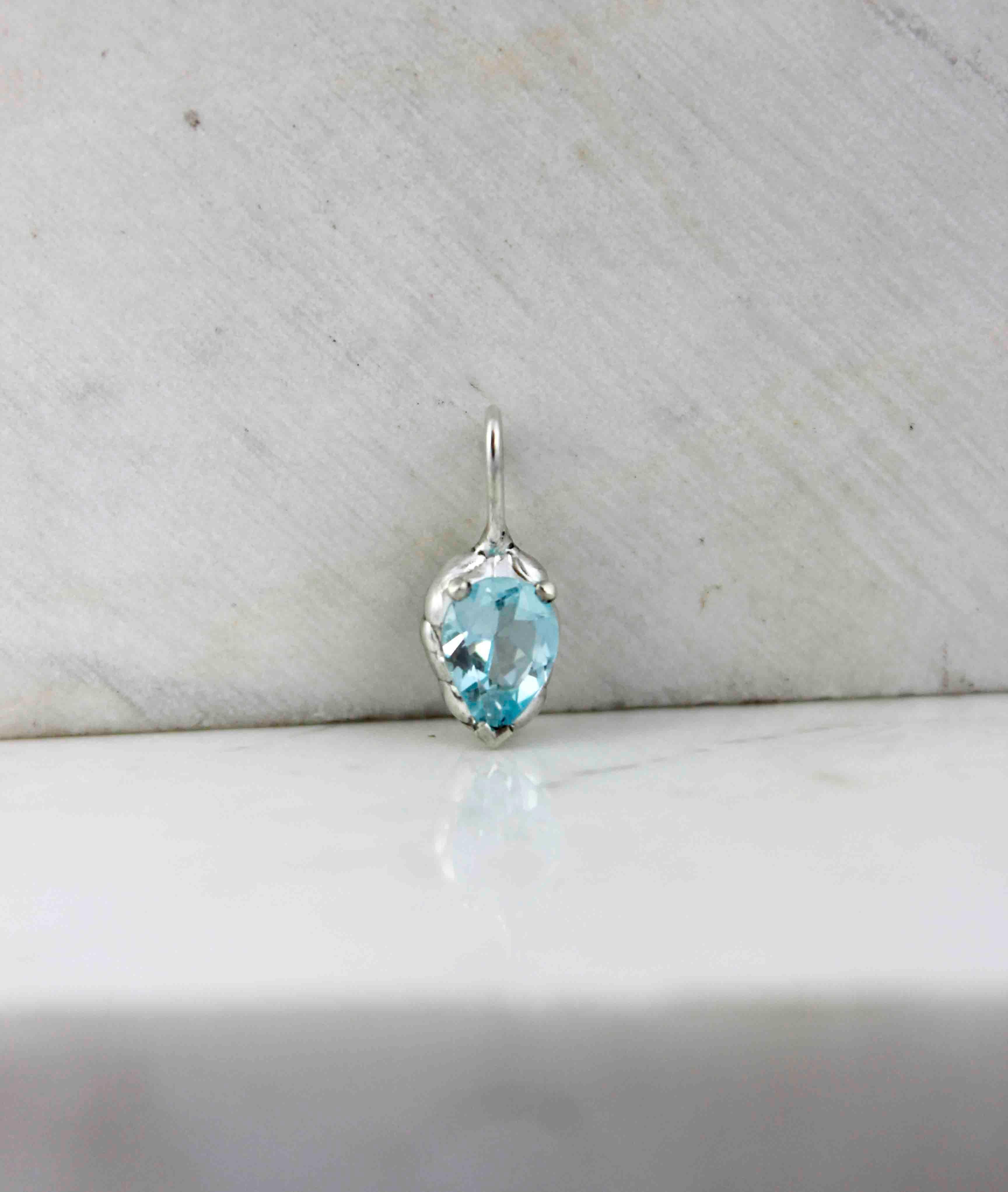 A delicate blue topaz necklace, which can also be worn as a charm, with your own chain.

You can choose to only get the charm necklace, and make your favourite combination. The hoop shape allows it to easily hang from any chain.

Alternative, you