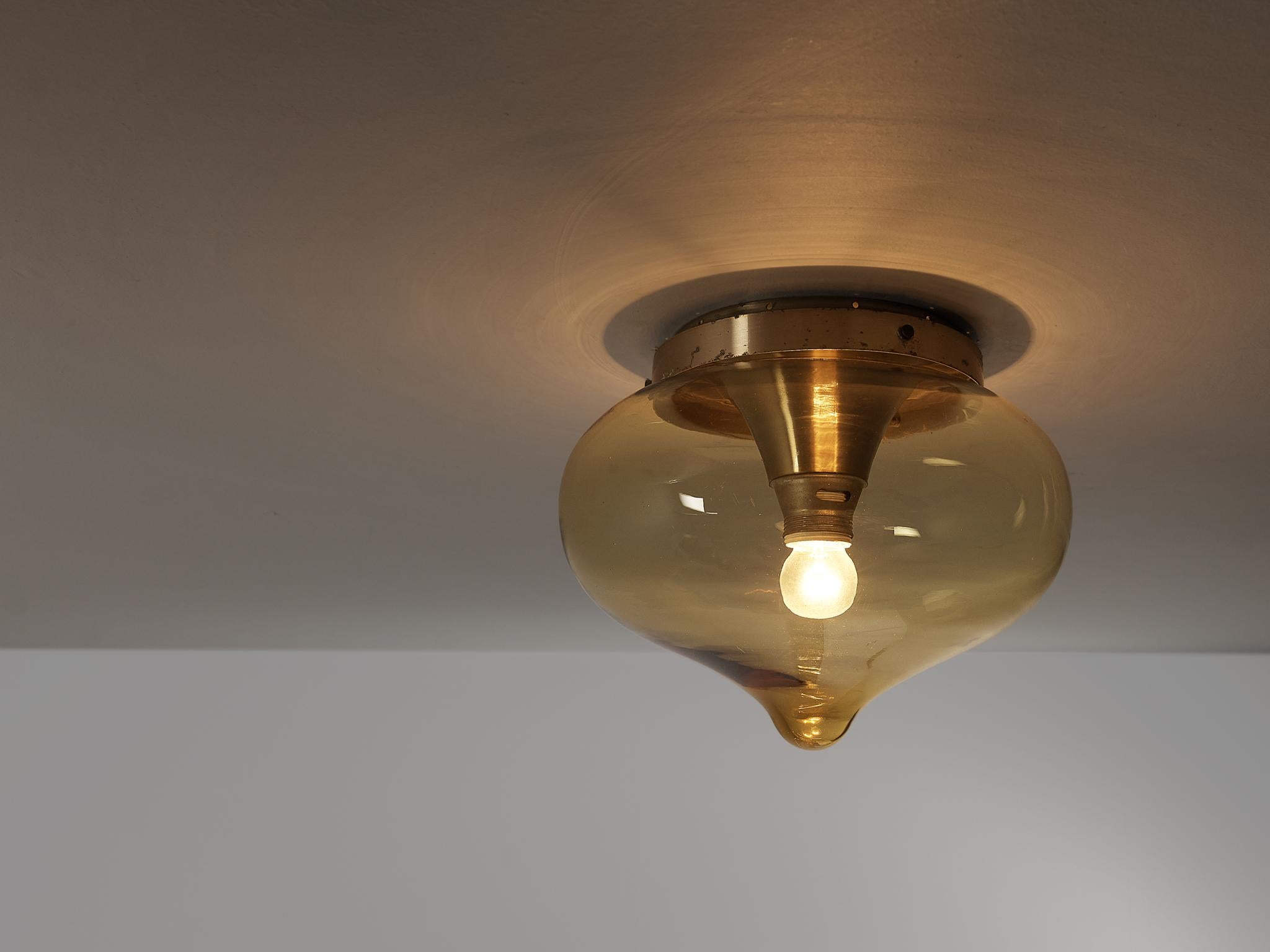 Ceiling light, brass, glass, aluminum, The Netherlands, 1960s

A tear drop shaped glass orb in a golden shade that radiates a warm and diffuse light. The light source reflects on the brass, enlightening the interior in a delightful manner. The