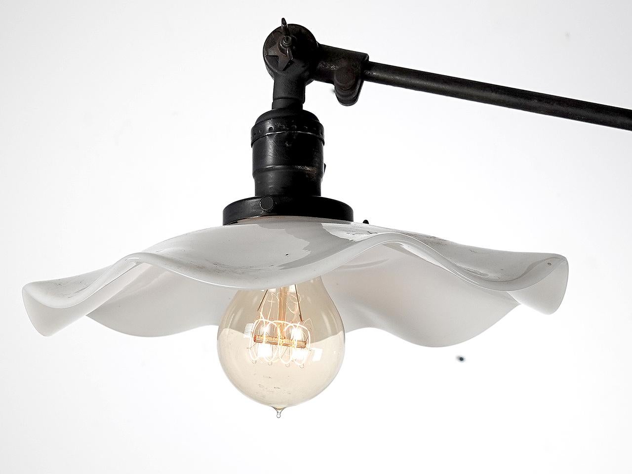 This beautiful floor lamp features a unique wavy milk glass shade. It has a very clean look and an articulated spiral spring joint. Its nice and sturdy with a heavy iron base.