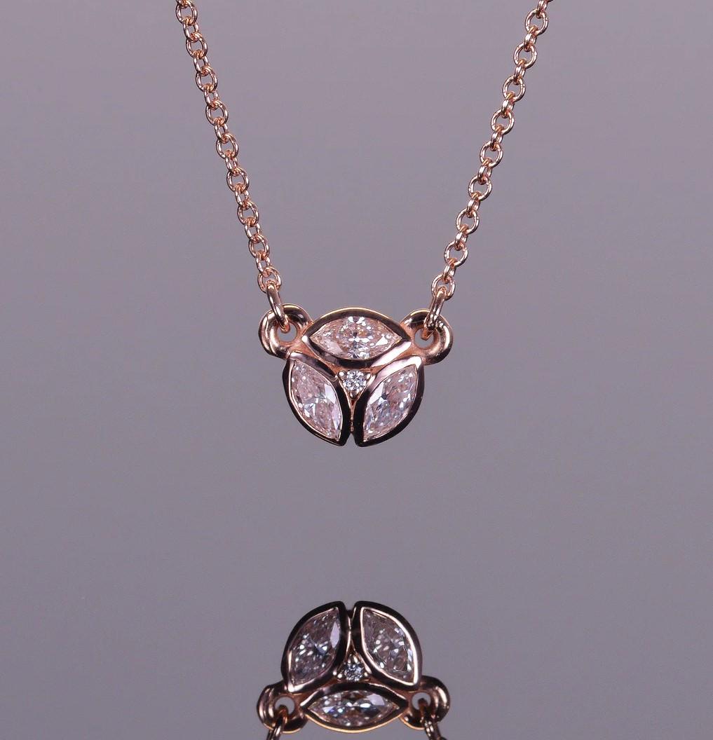 LXV collier pendentif délicat en or rose 14k composé de diamants taillés en marquise. Le pendentif est orné de trois diamants de taille marquise et d'un diamant rond, le tout totalisant 0,32 carat.