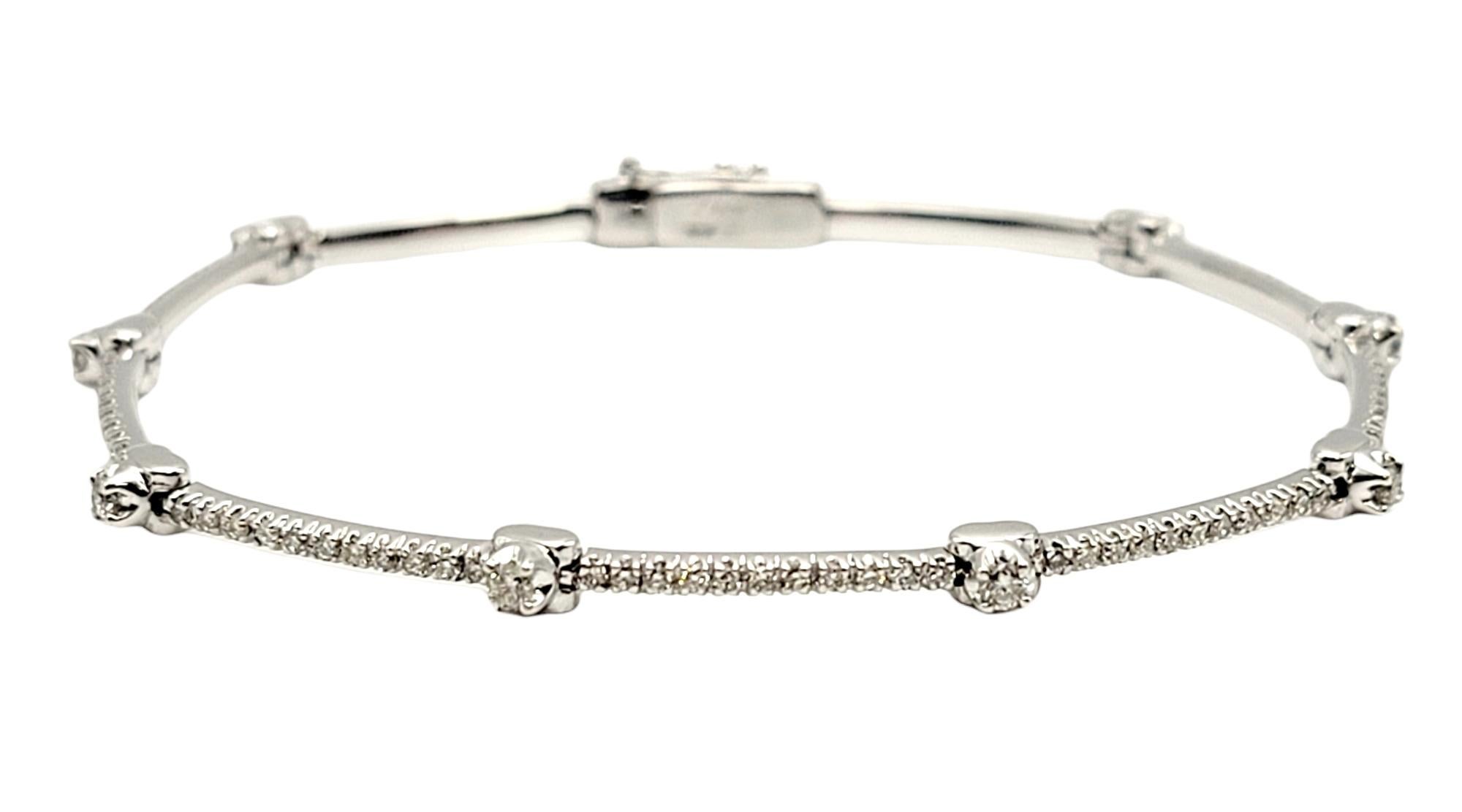 Bracelet station ultra-féminin avec des détails en diamants éblouissants. Douze grands diamants naturels accentuent la pièce en or blanc poli, tandis que le reste du bracelet est rempli de 99 autres pierres étincelantes. Délicate, classique et