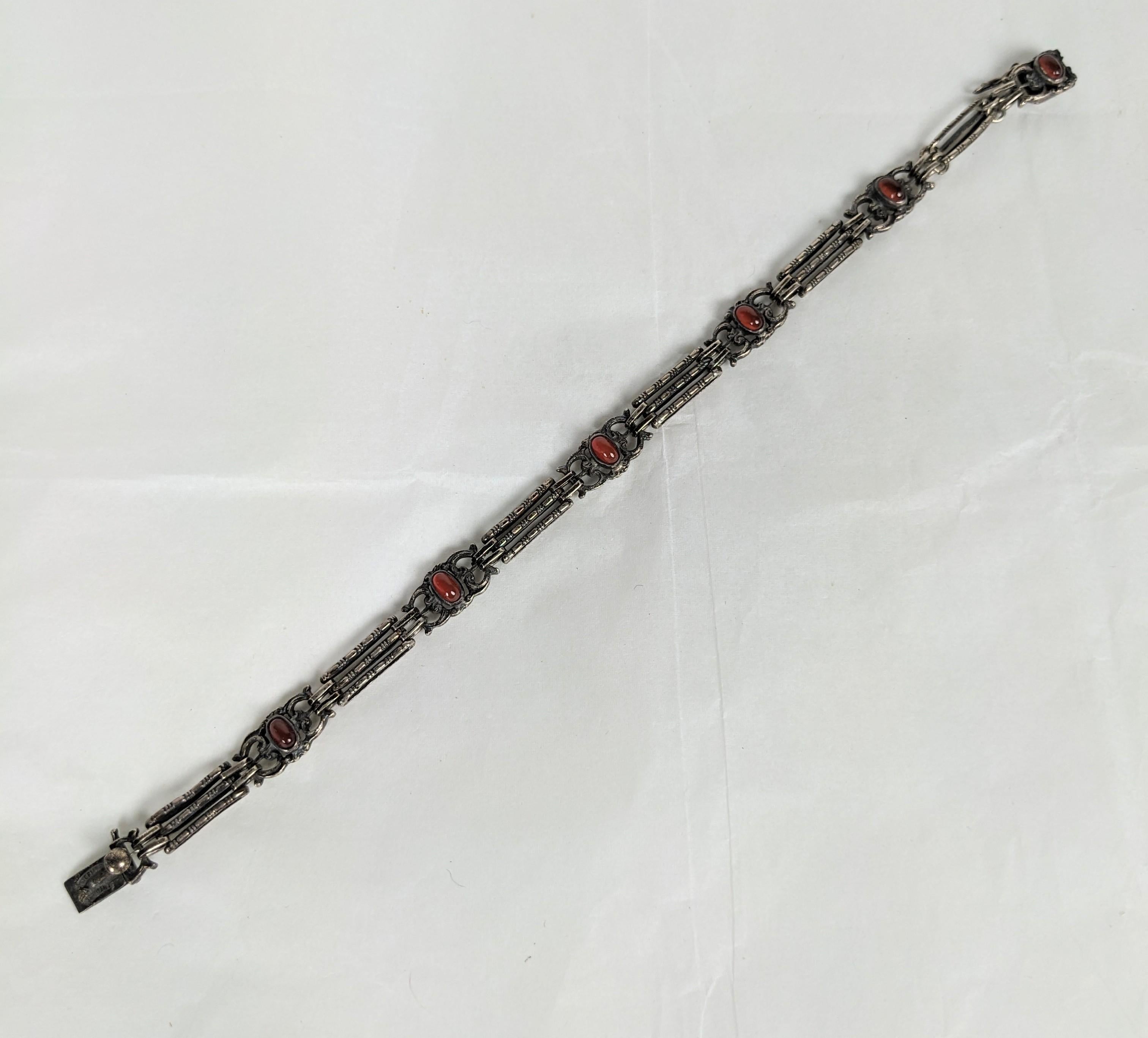 Delicate Sterling and Carnelian Bracelet from the 1920's, Germany. Handmade with long spacer links spaced with cartouches of oval carnelian cabochons. Safety lock on clasp. 
1920's Germany Sterling Signed. 7.5
