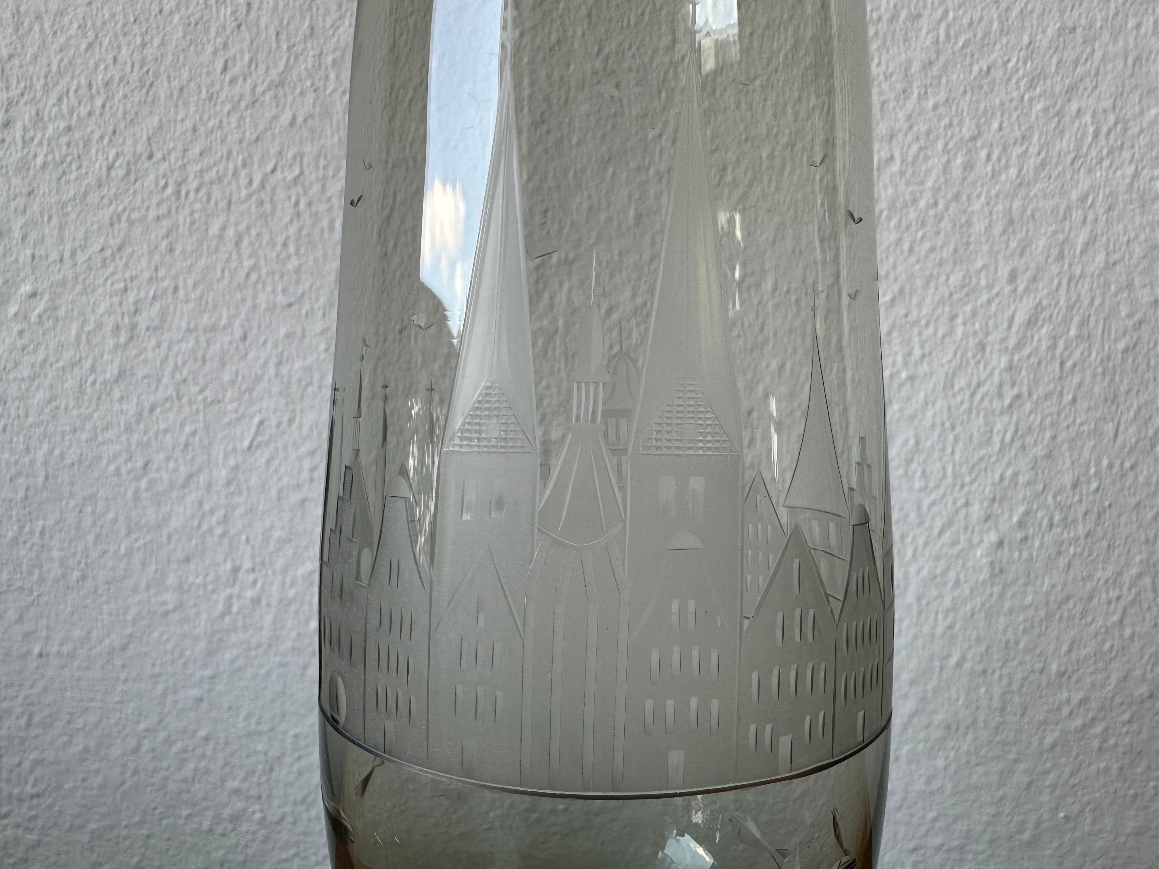 This elegant smoky grey glass vase was created by renowned German glass artist Carl Rotter, whose workshop in Lübeck became known for its exquisite craftsmanship and distinctive engravings. The vase is made from particularly fine, delicate glass