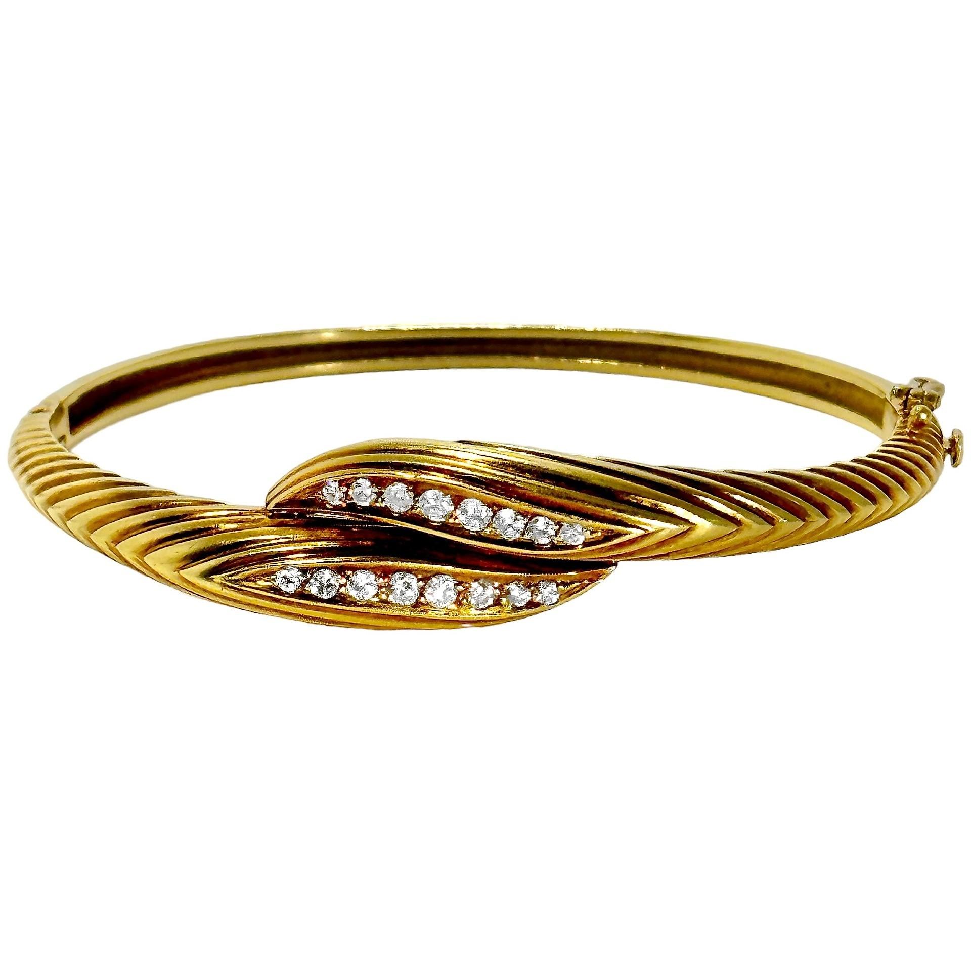 This lovely Mid-20th Century 18k yellow gold hinged bangle bracelet with diamonds exhibits true French Panache. It is deftly crafted with attention to details.
At the center, sixteen brilliant cut diamonds are set and have a total approximate weight