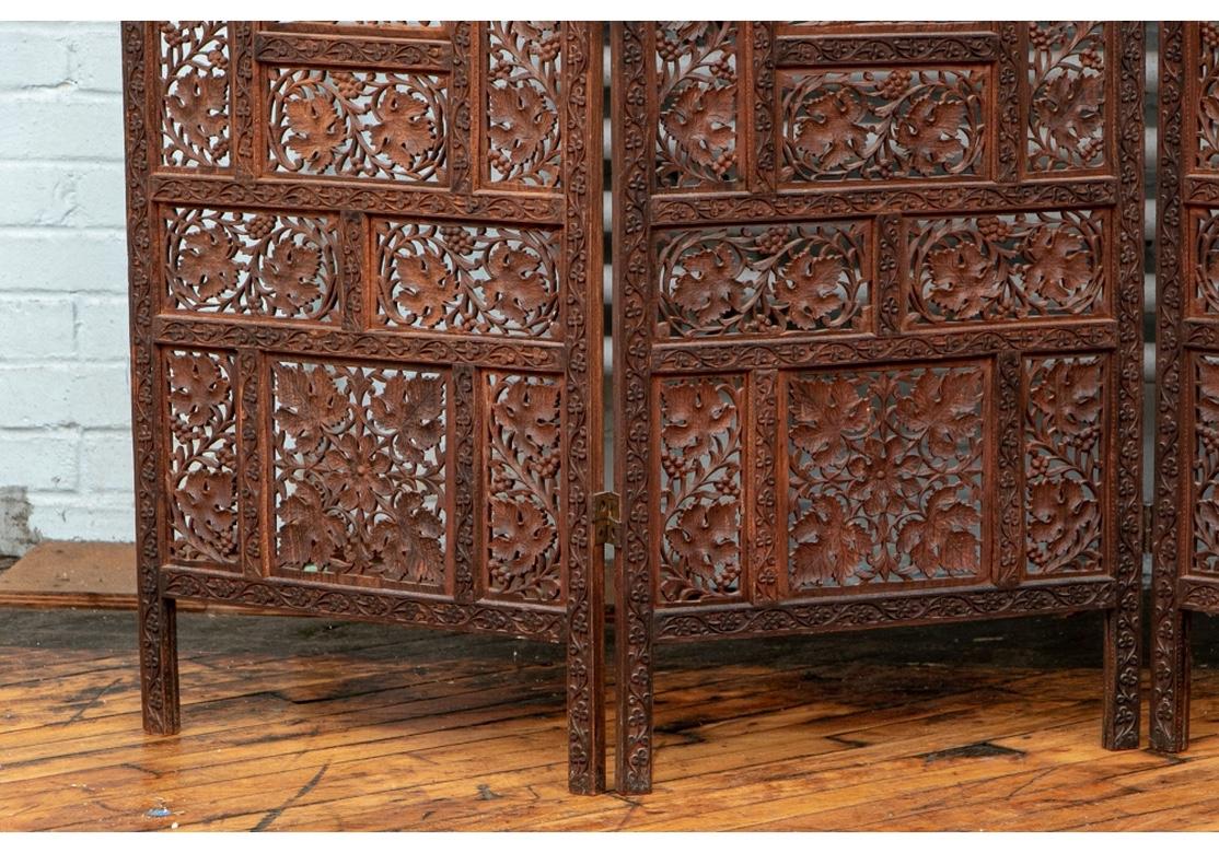 A very finely carved four panel wooden screen from India. The all over carving theme is leaves and grapes with twining vine carving on the uprights and cross bars.
Each panel is 19 1/2