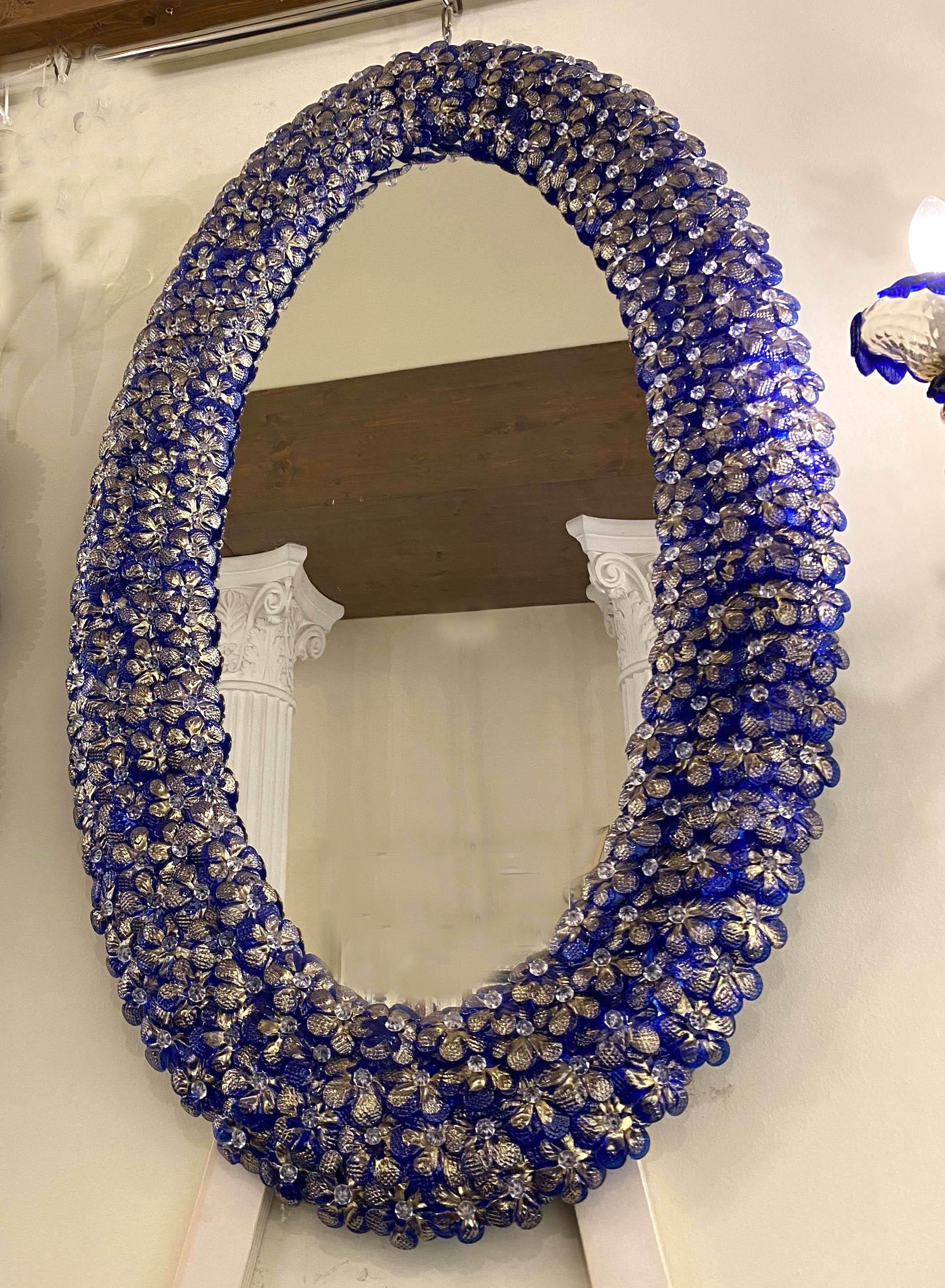 Italian Murano glass mirror with dozens of graceful hand blown blu and gold flowers.
Available also the pair.