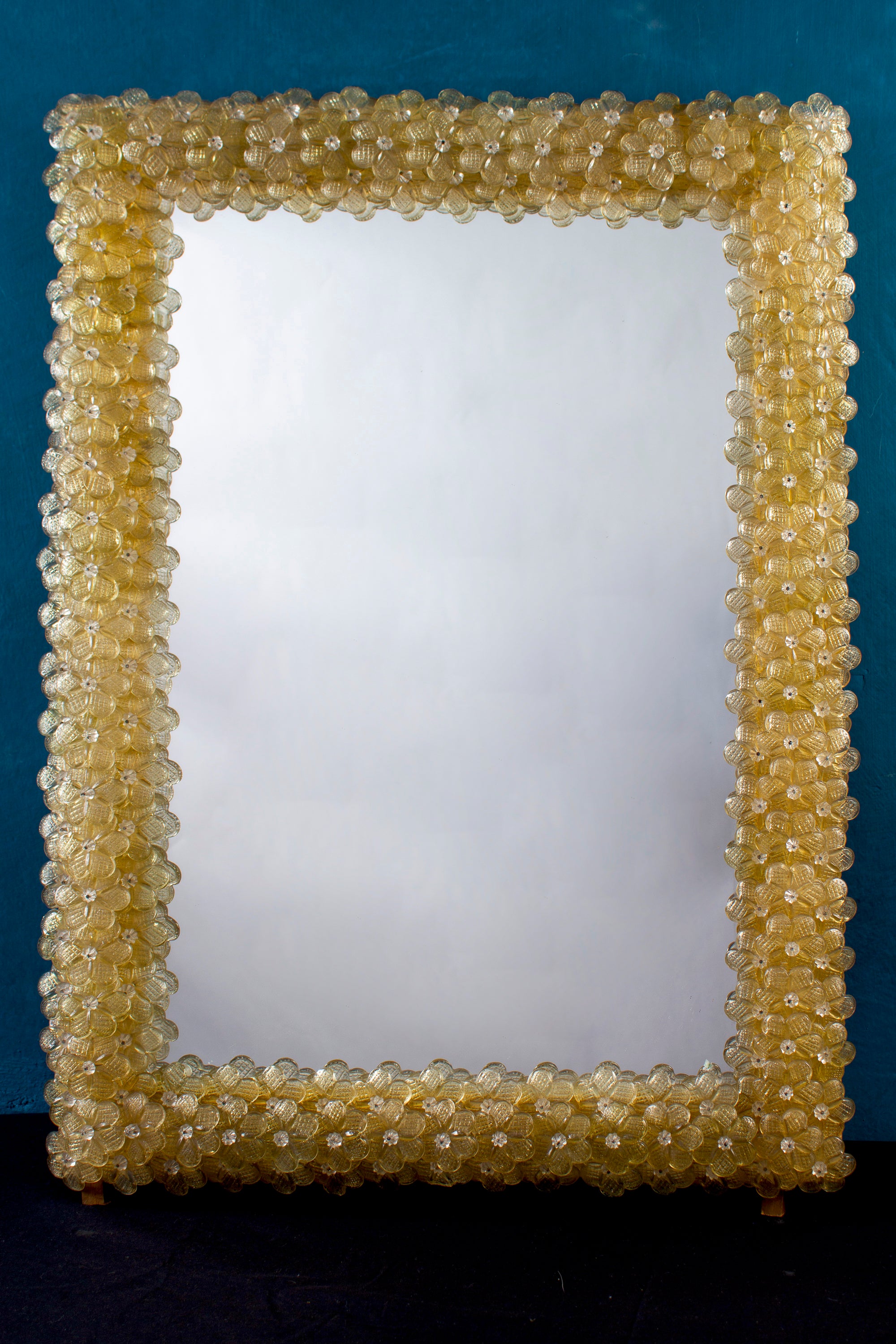 Italian Murano glass rectangular mirror with dozens of graceful hand blown gold color flowers.
Available also with acquamarine blue color the same dimension.