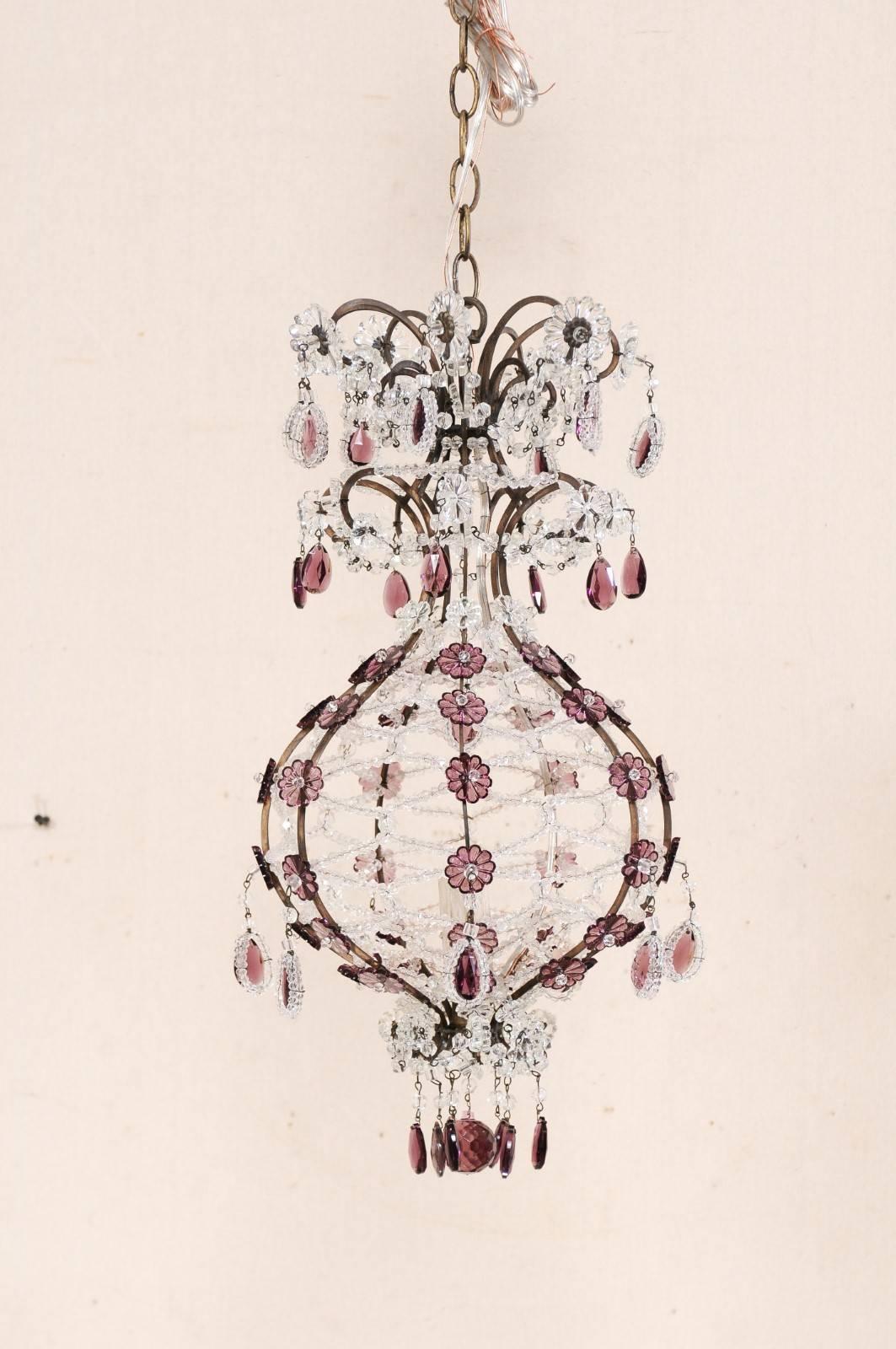 An Italian crystal and glass single-light chandelier from the mid-20th century. This vintage Italian chandelier features a clear and amethyst colored crystal and beaded glass decorated ballooned-shaped body, having a single light within its caged