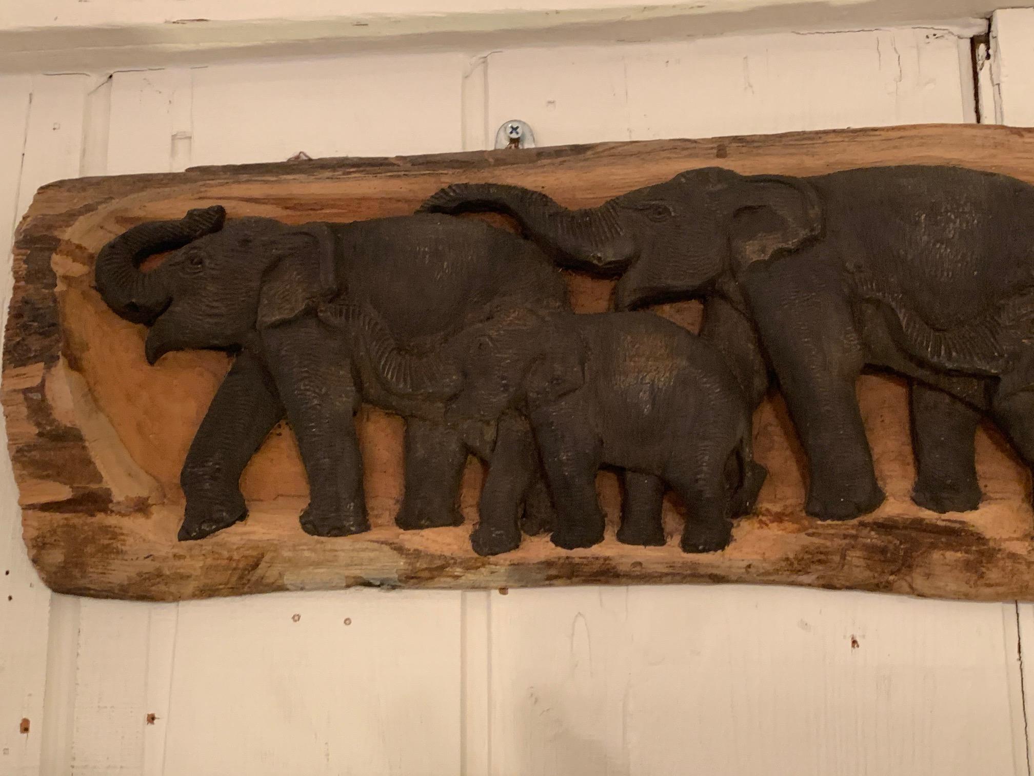 Handsome carved wood wall relief sculpture of a family of 5 elephants in a horizontal line.