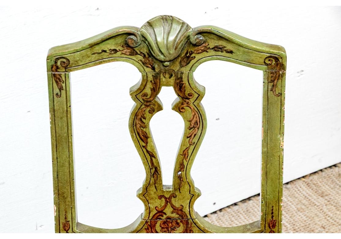 A diminutive, colorful and custom upholstered pair of Antique Chairs. Likely Italian, the Pair have a fine deep Avocado base paint with Scroll and Foliate accents on corner blocked carved frames having stylized Shell top piece, openwork back,