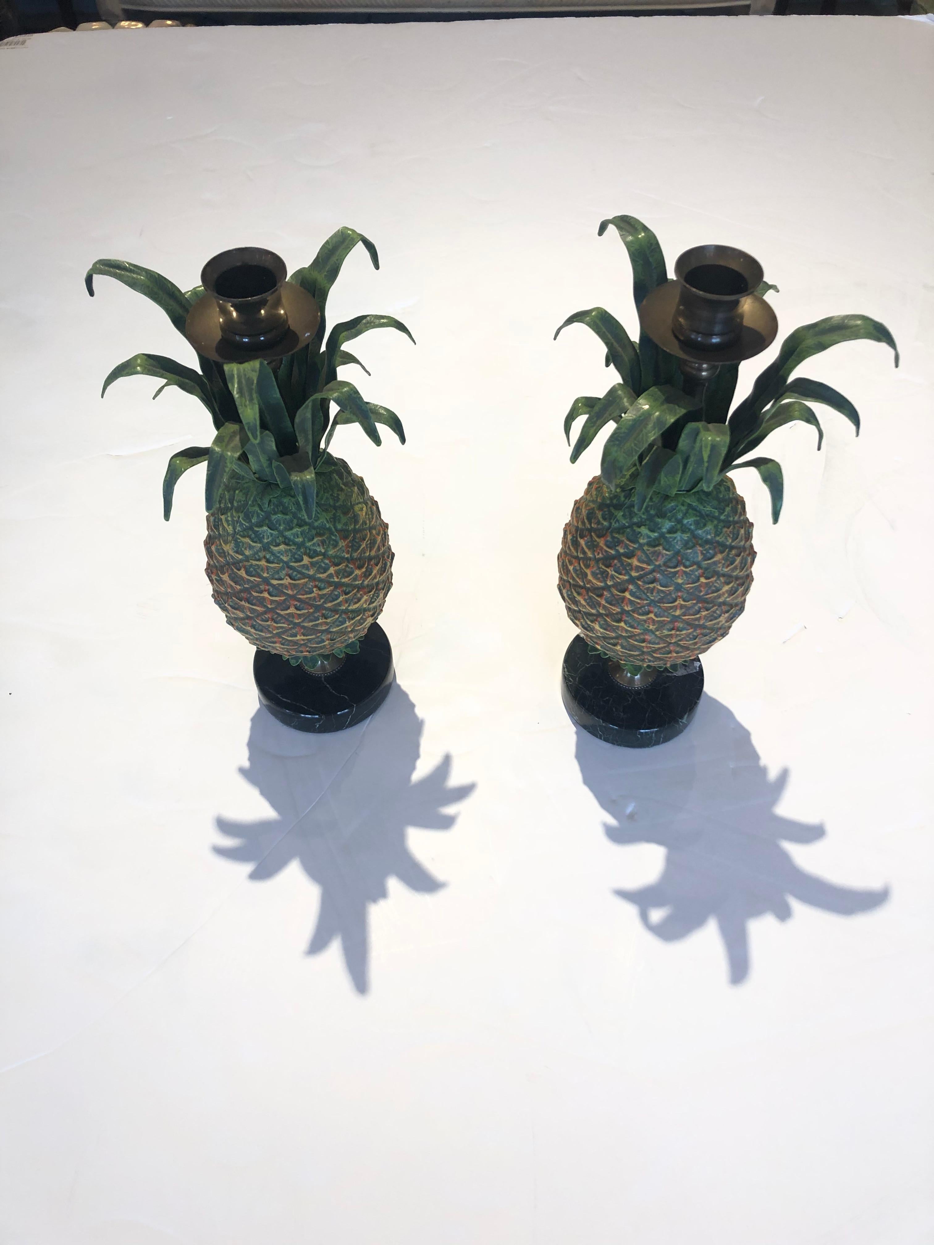 An eye-catching pair of painted tole, iron and brass candlesticks having wonderful pineapple motife.