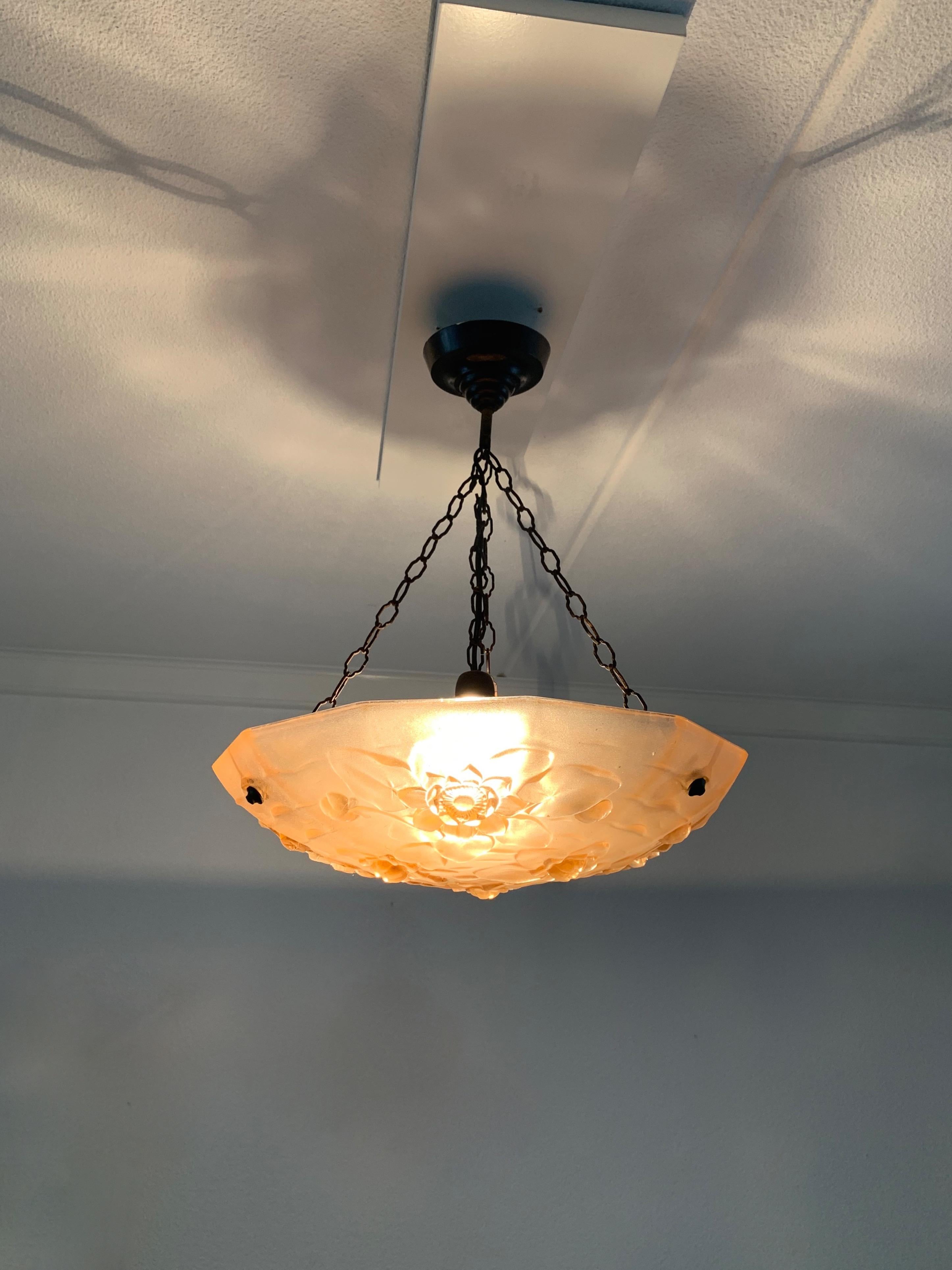 Very stylish and rare 1920s Art Deco pendant light with a beautiful color.

Both with the light switched on and off, the iridescence of the glass flower theme is of a beauty that will lift your spirit like no modern day pendant ever could. This