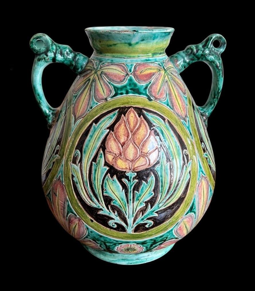 5298

Substantial Della Robbia twin handled exhibition vase.

With a full decoration of stylised flower heads and foliage

Designed and decorated by Charles Collis, Casandra Walker and John Fogo

Frit to body and rim

Measuring 32.5cm high