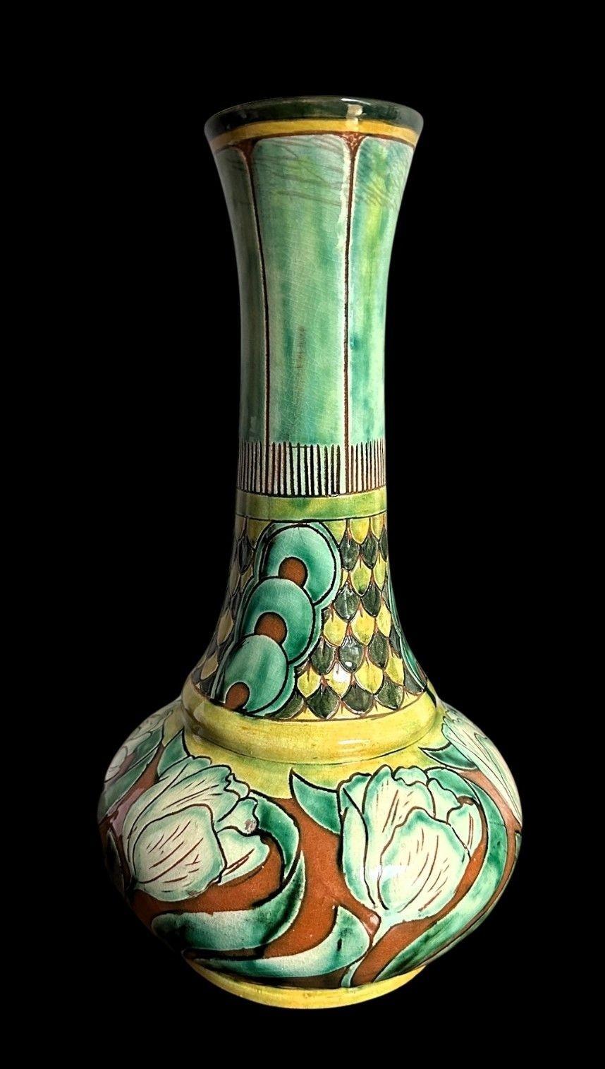5484
Large Della Robbia Vase decorated in an Art Nouveay Design of Stylised Tulips below a scolloped neck by Charles Collis
Light crazing with a little staining to the neck and a glaze frit to the body
32cm high, 16cm wide
Circa 1900