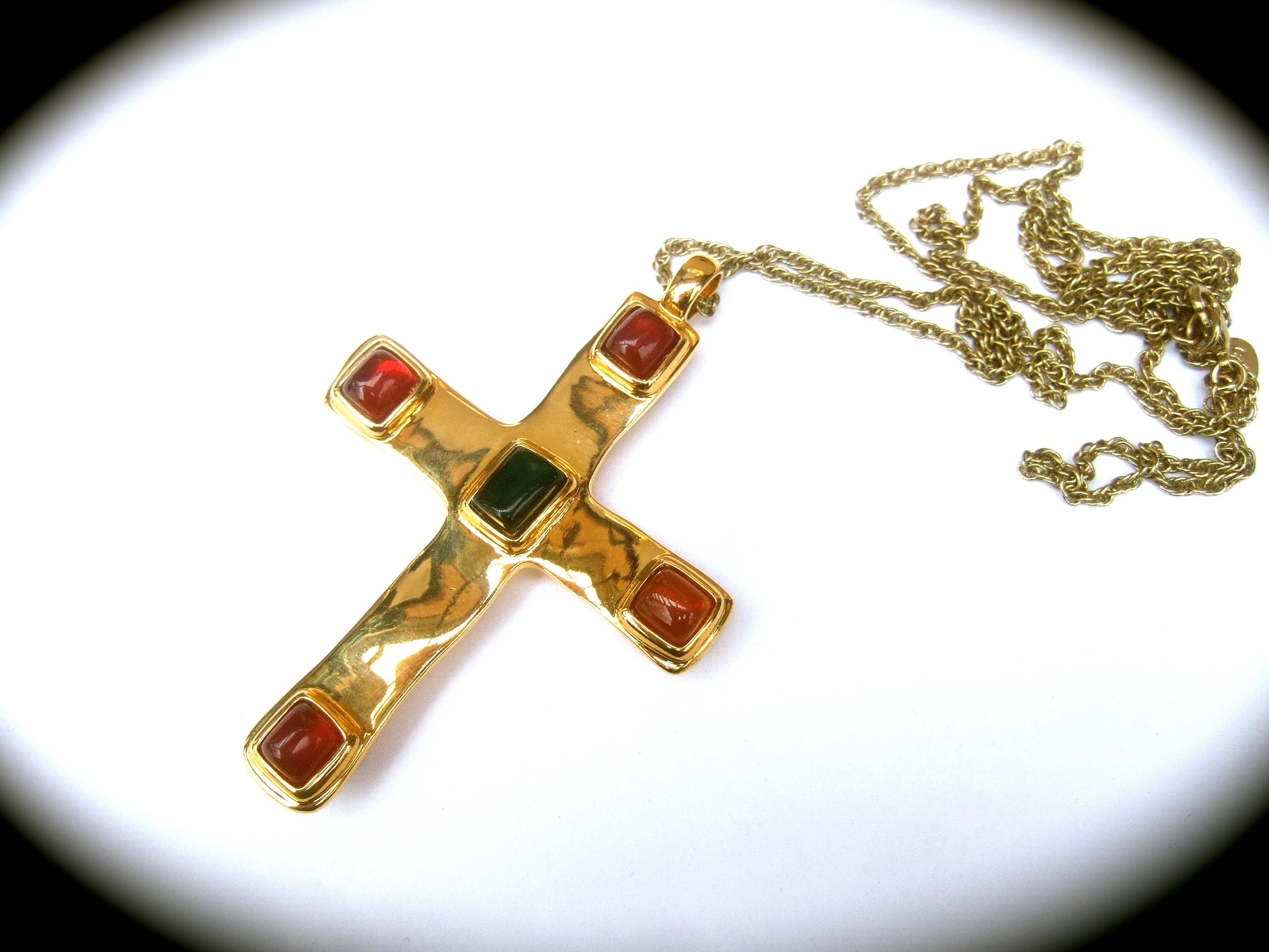 Dellio Large gilt metal poured resin cabochon pendant necklace
The large scale shiny gilt metal cross is embellished with jewel tone square smooth resin cabochons in a myriad of colors 

The collection of smooth resin cabochons are mounted on both