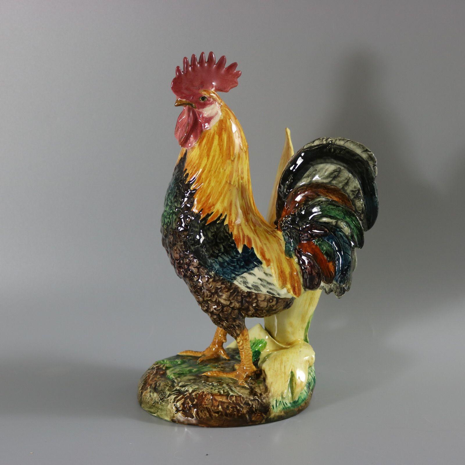 Vase figuratif en majolique de Delphin Massier représentant un coq/coq devant un vase modelé en forme de maïs. Coloration : jaune, rose, bleu sarcelle sont prédominants. La pièce porte les marques de fabrique de la poterie Delphin Massier.