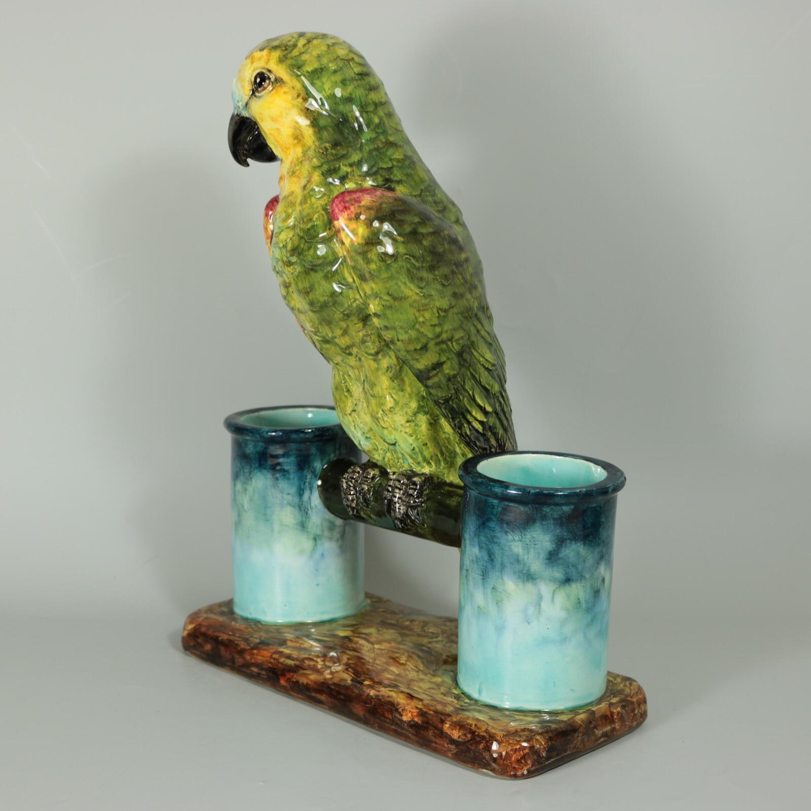 Delphin Massier French Majolica figural vase which features a green parrot perched in-between two cylindrical vases. Colouration: green, blue, yellow, are predominant. The piece bears maker's marks for the Delphin Massier pottery.