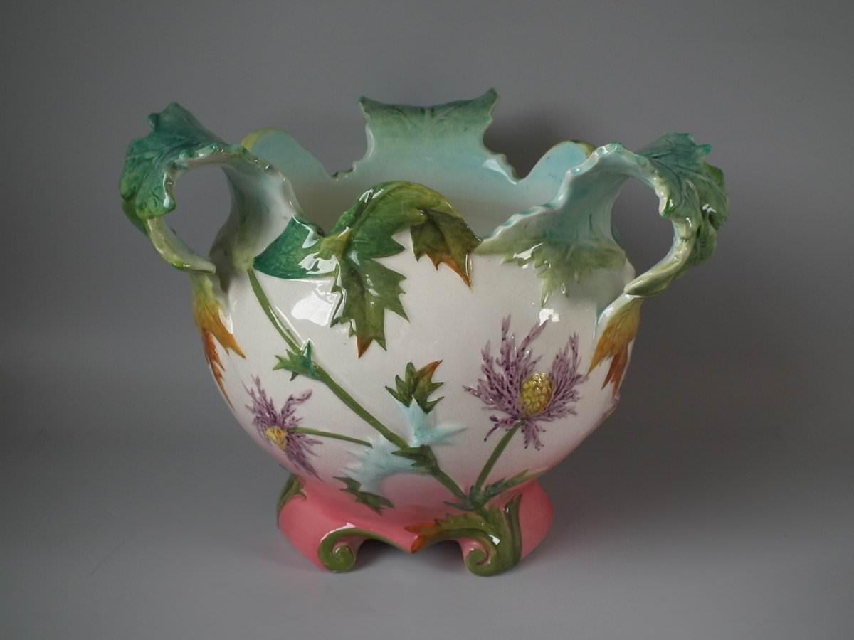 Delphin Massier Majolica jardinière which features flowering thistles. Coloration: cream, pink, green, are predominant. The piece bears maker's marks for the Delphin Massier pottery.