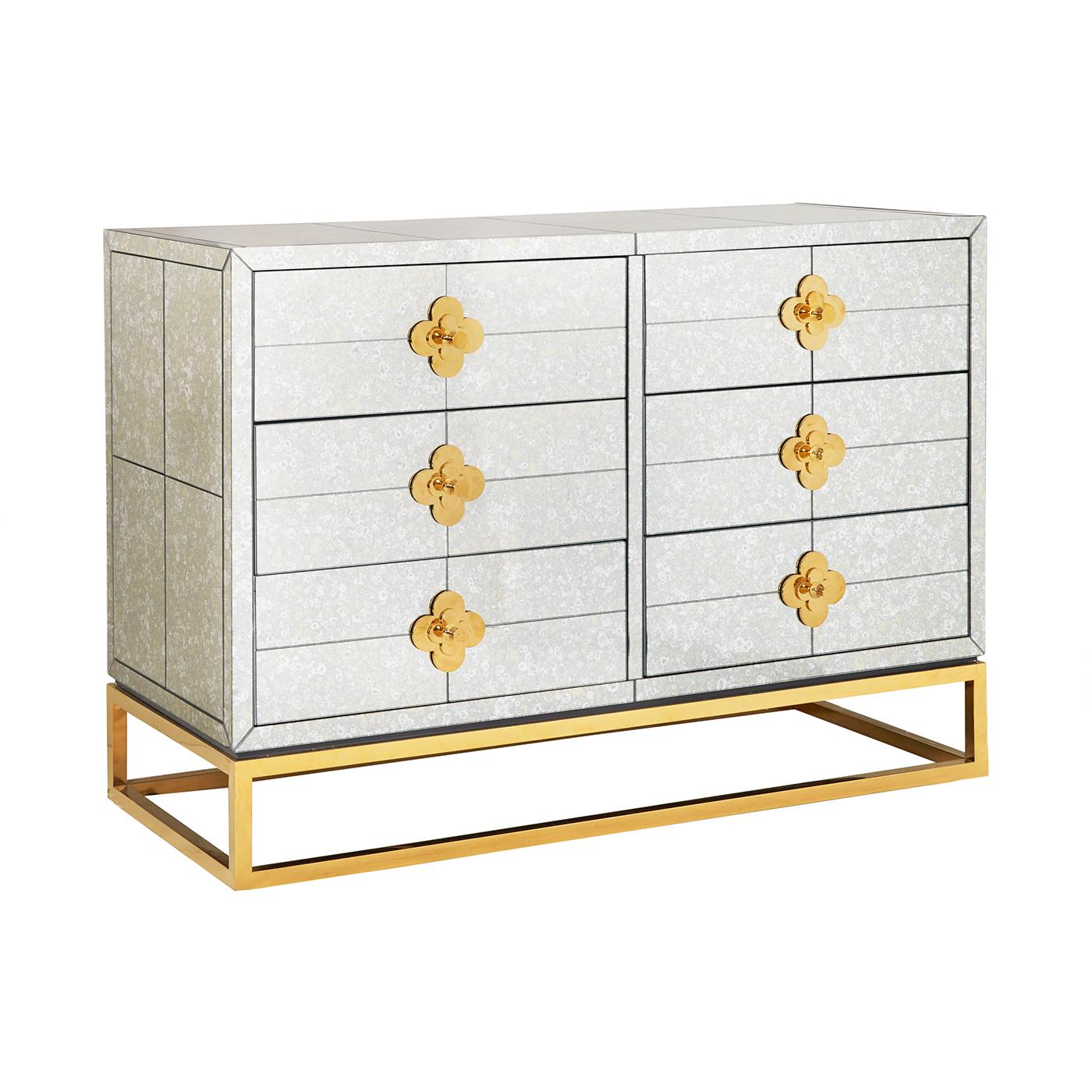 Reflectology. Minimalist forms meet Maximalist glamour. Our Delphine six-drawer dresser features antiqued mirror with a polished brass base and jewel-like quatrefoil escutcheons. Each drawer opens to reveal a bright robin's egg blue interior.
