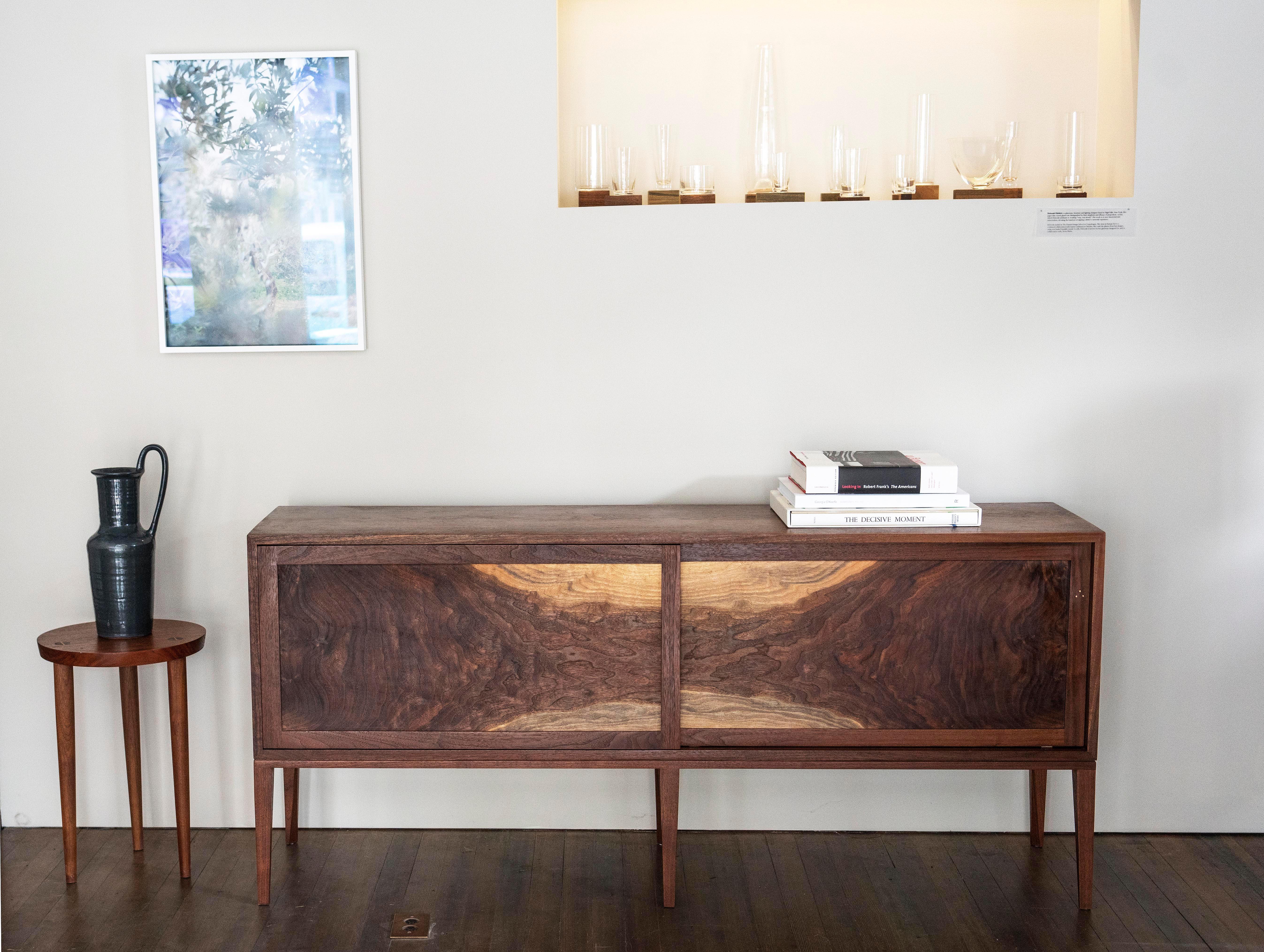 One of a kind. Two large sliding flat panel doors are the centerpiece for this Hudson Valley walnut cabinet; bookmatched flames radiating inwards are set off by two arches of pale sapwood. On the rear door, a bright but subtle moment of copper