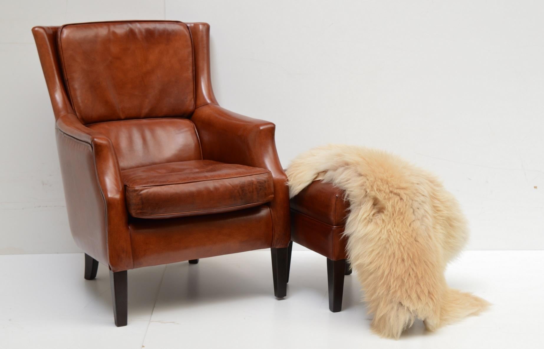 Made in the Netherlands: Elegant chair new to order for a customer who wanted to combine his Chesterfield couch with a more plain model chair. Without the buttons we make a range of sheep hide upholstered furniture to fit with Chesterfield items.