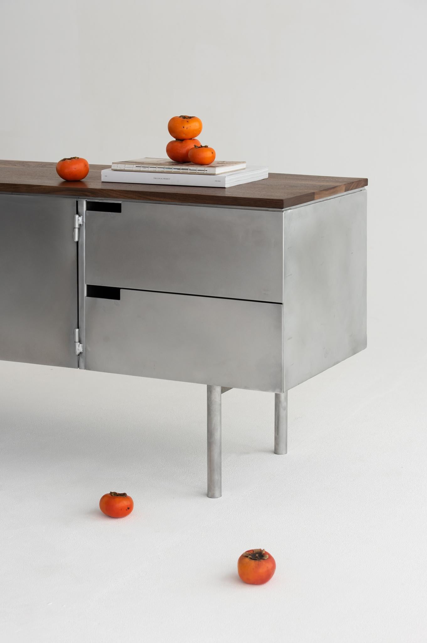 La credenza Delta abbraccia il contrasto tra i materiali: la bellezza grezza dell'alluminio abbinata al calore del legno. Progettato con forme semplici, proporzioni ben bilanciate e per essere assolutamente funzionale.

Il suo corpo è realizzato con