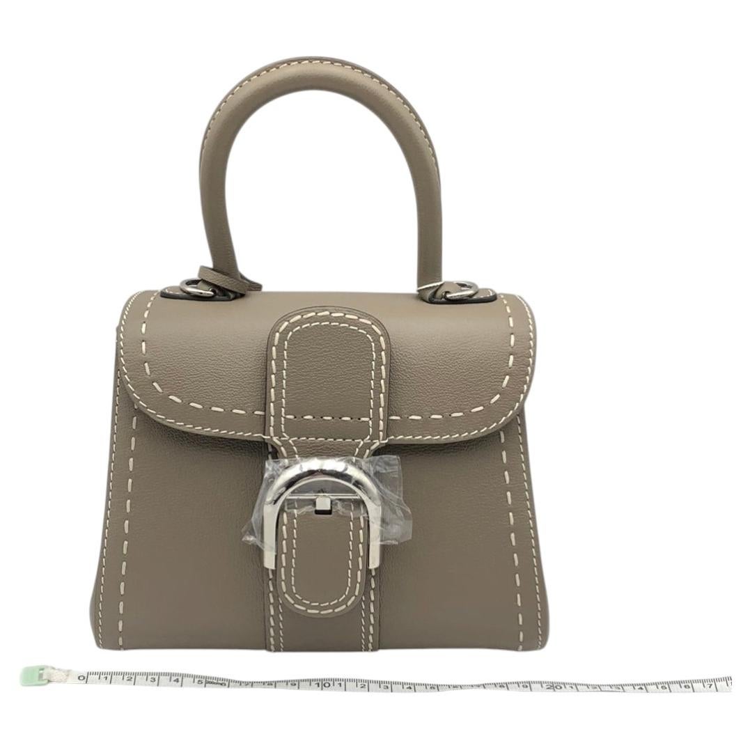 Sac Delvaux Brillant Mini Surpique, couleur « Tourterelle Grey », en cuir de veau Rodeo, finition argentée