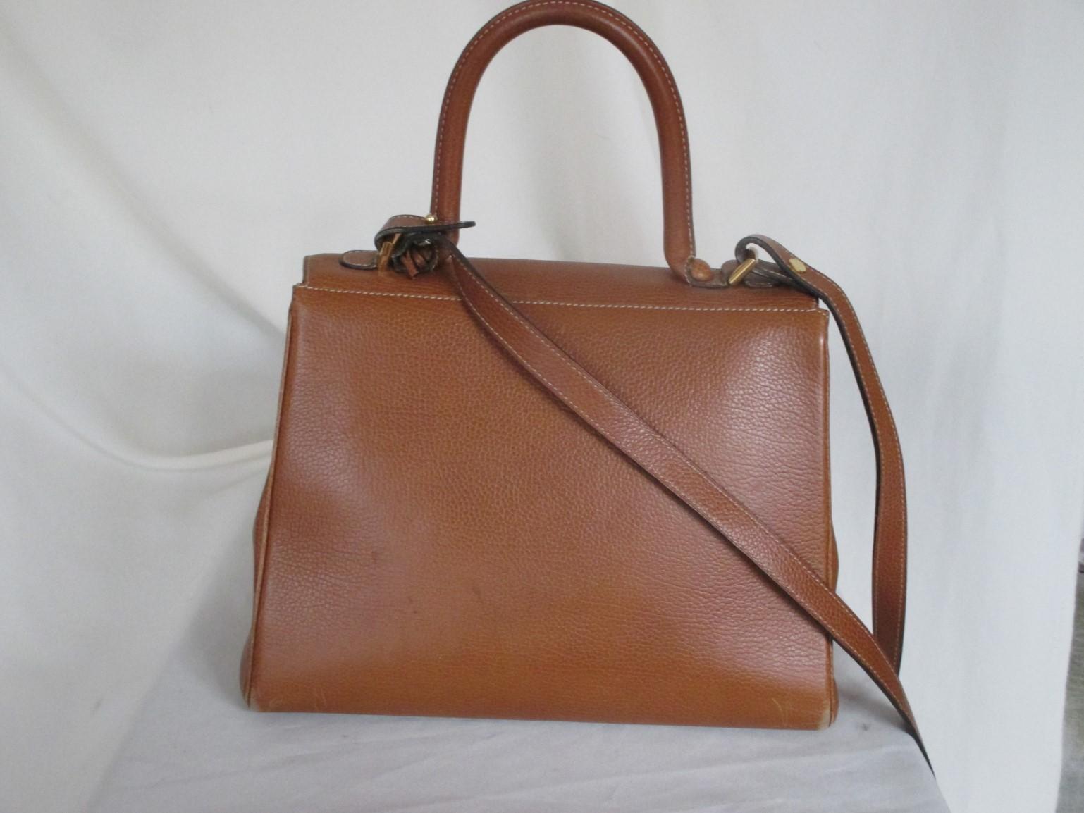 This vintage bag is made of cognac brown calfskin leather with gold hardware, can be worn as cross body-hand or shoulder bag.
Model: Delvaux Brilliant MM, designed in 1958.
Lining is leather suede with 1 zip pocket and 1 open pocket. The leather has