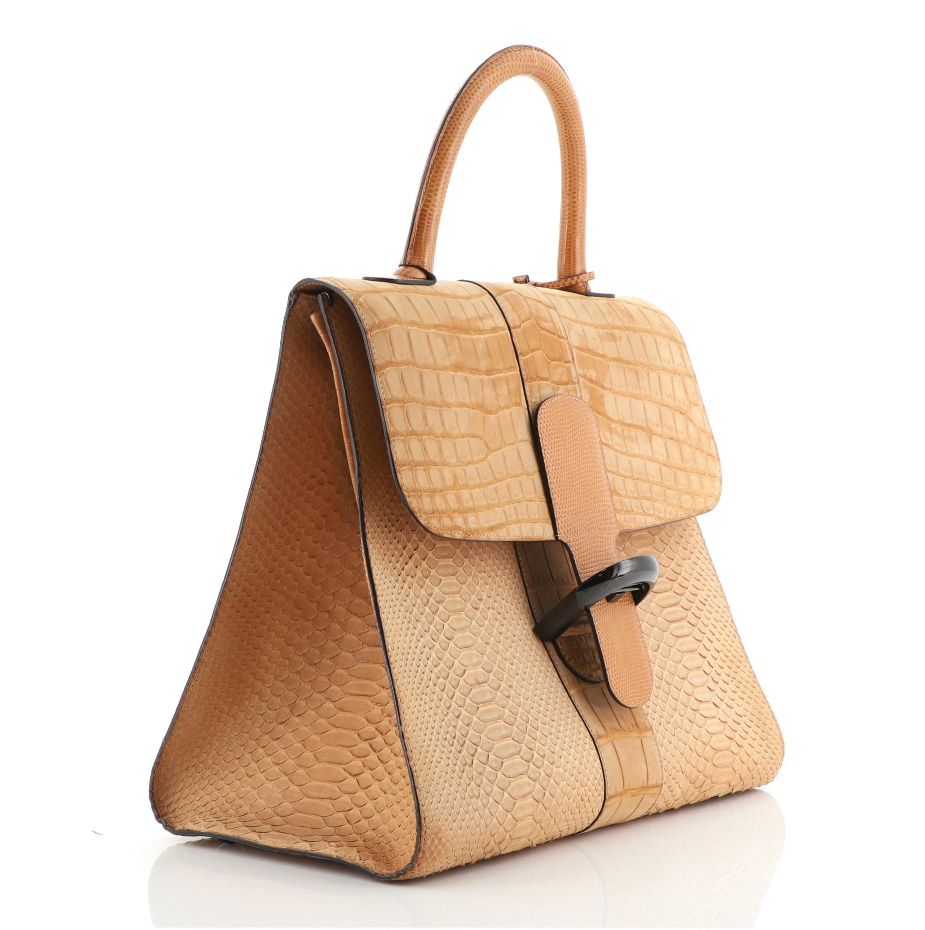 Delvaux Brillant Top Handle Bag Mixed Exotics GM
Brown

Condition Details: Moderate darkening on flap, scuffs on exterior and in interior, minor splitting on opening flap wax edges. Bubbling underneath flap, indentations in interior, scratches on